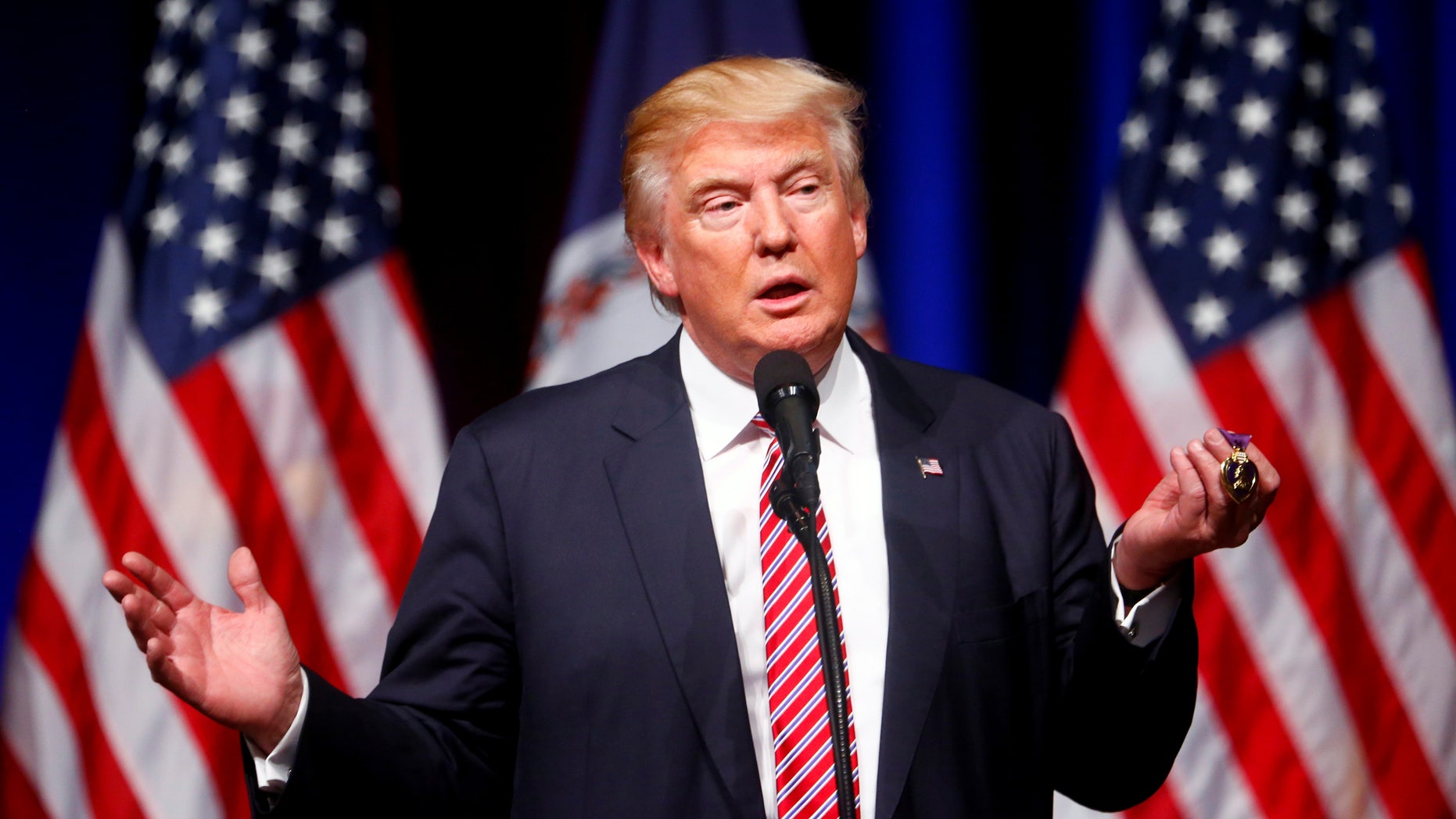 Republican U.S. Presidential nominee Donald Trump holds up a Purple Heart during a campaign event at Briar Woods High School in Ashburn, Virginia, U.S. August 2, 2016. REUTERS/Eric Thayer - RTSKQZF
