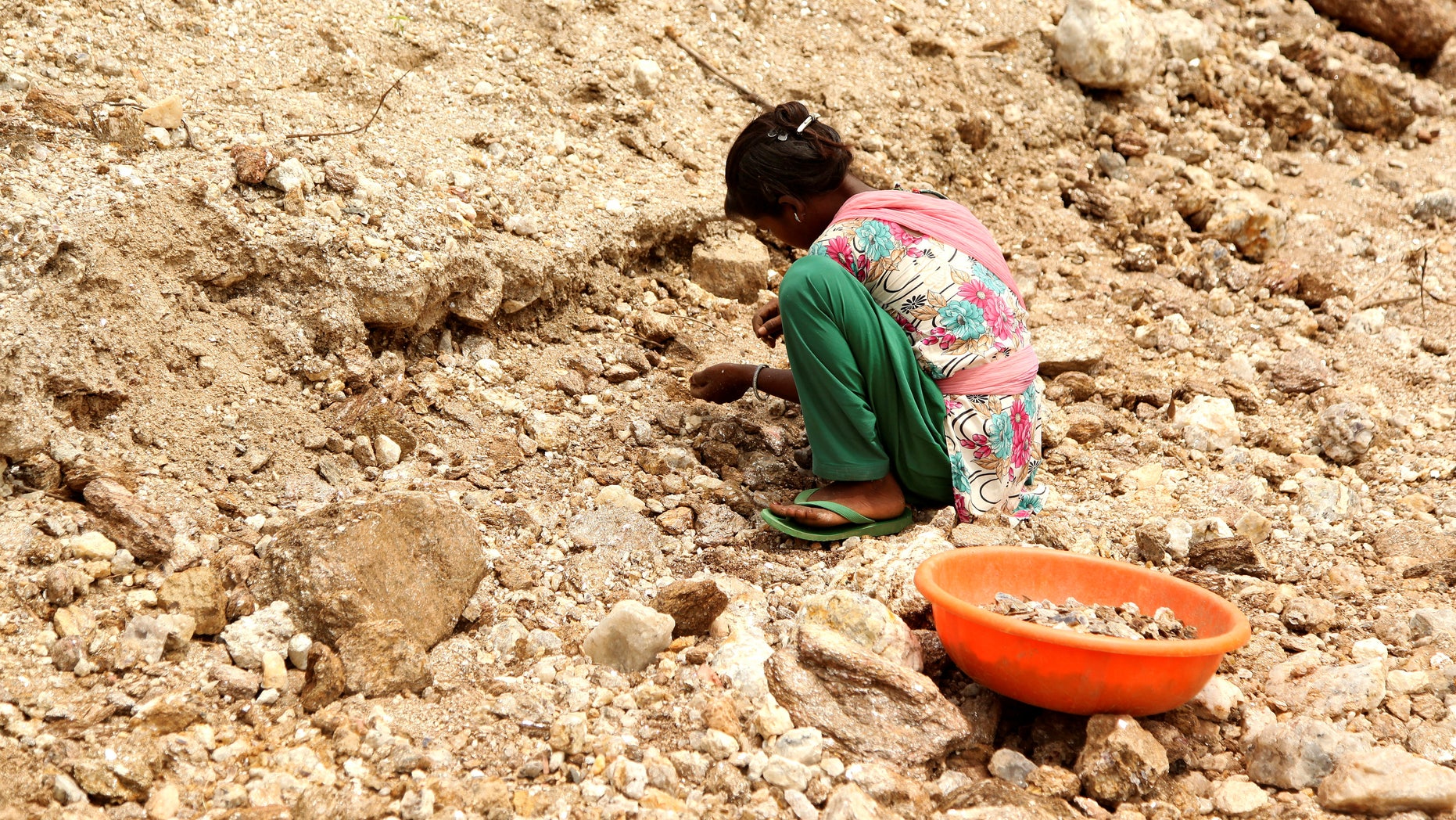 Gudiya, 13, breaks away pieces of mica from rocks in an illegal open cast mine in Koderma district in the eastern state of Jharkhand, India, June 29, 2016. Picture taken June 29, 2016. To match Thomson Reuters Foundation INDIA-MICA/CHILDREN REUTERS/Nita Bhalla - RTSKS2A