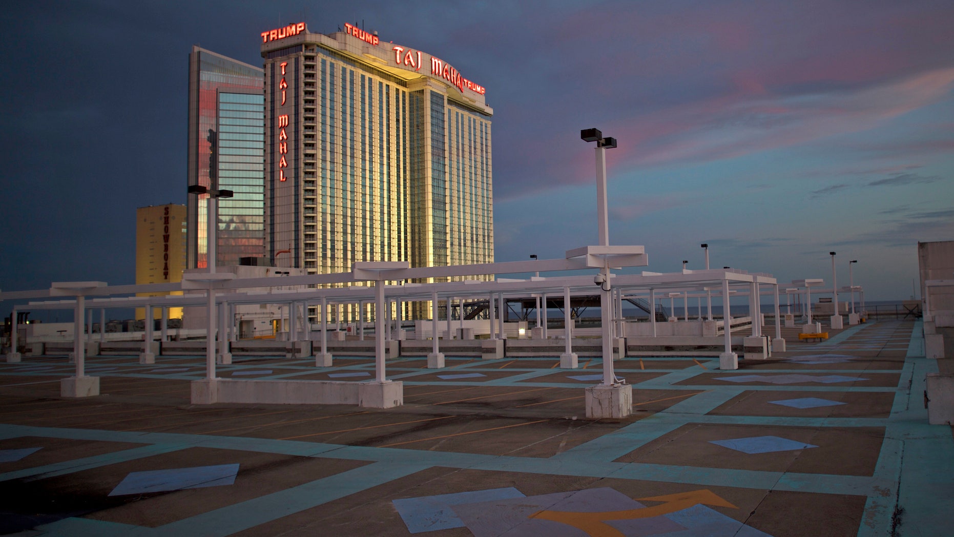 The illuminated Trump Taj Mahal Casino is seen from a rooftop parking lot at dusk in Atlantic City.