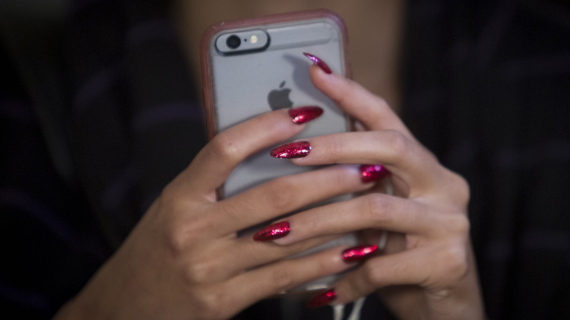 A model's nails are seen as she uses her cell phone backstage before the Betsey Johnson Spring/Summer 2016 collection presentation during New York Fashion Week in New York, September 11, 2015.