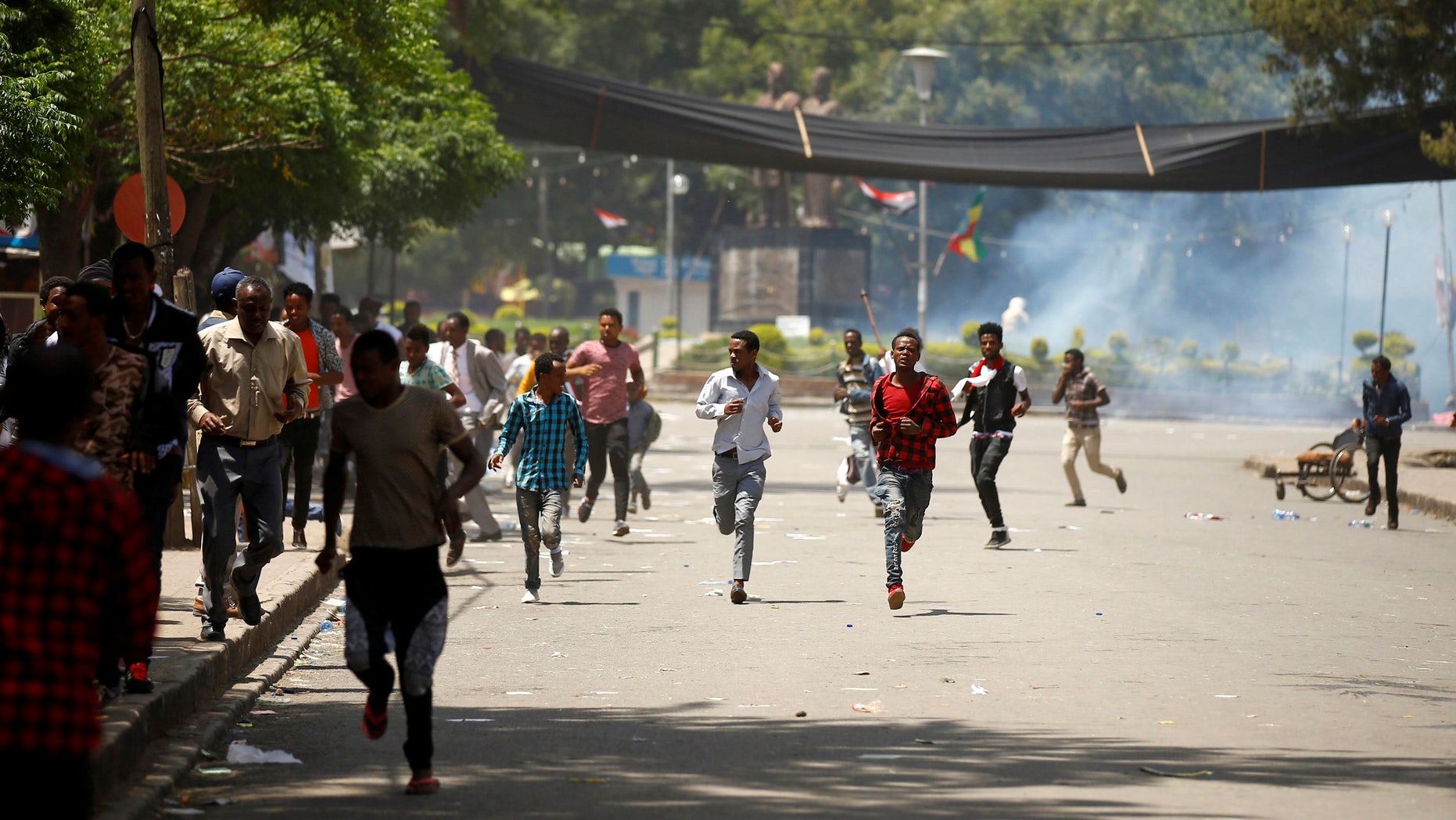 Protesters run from tear gas fired by police.