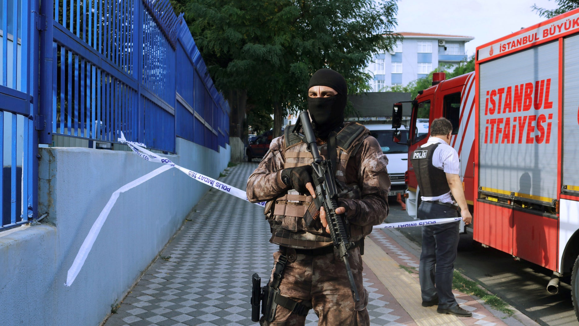 A member of police special forces stands next to a fire truck near the blast site in Istanbul.