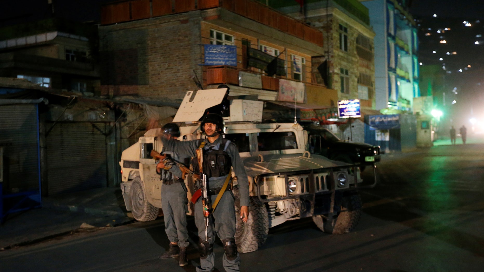 Afghan policemen stand guard near the site of the attack in Kabul.