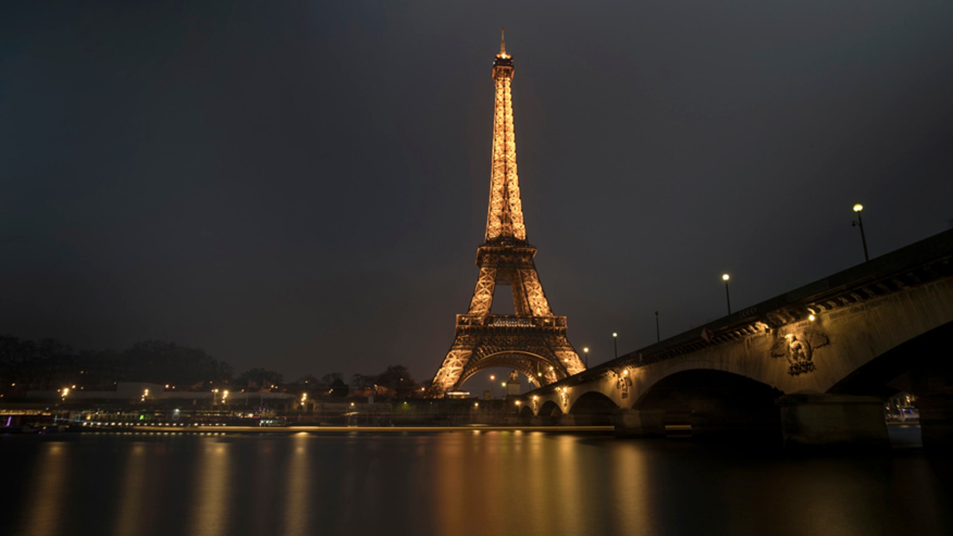 A streak of light from a passing boat is seen in this long time-exposure of the illuminated Eiffel Tower and the Seine River in Paris, France, January 17, 2017. REUTERS/Philippe Wojazer - RTSVY77