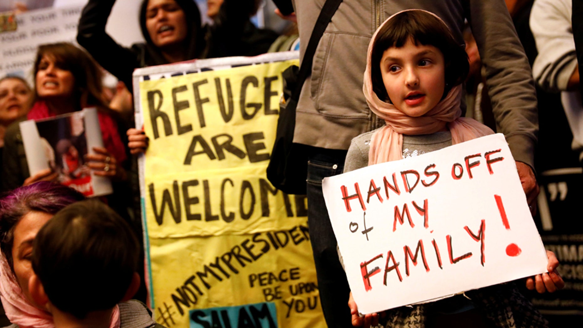 Rosalie Gurna, 9, holds a sign in support of Muslim family members as people protest against U.S. President Donald Trump's travel ban on Muslim majority countries, at the International terminal at Los Angeles International Airport (LAX) in Los Angeles, California, U.S., January 28, 2017.