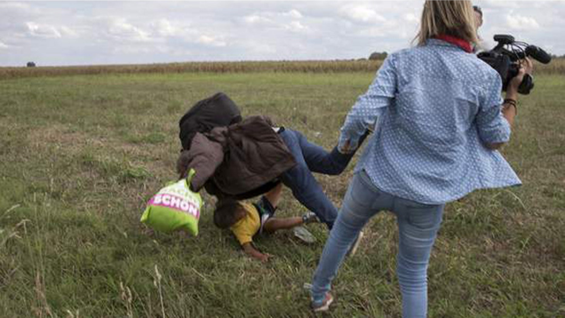 A camerawoman who was filmed tripping up a refugee says she plans to sue him.