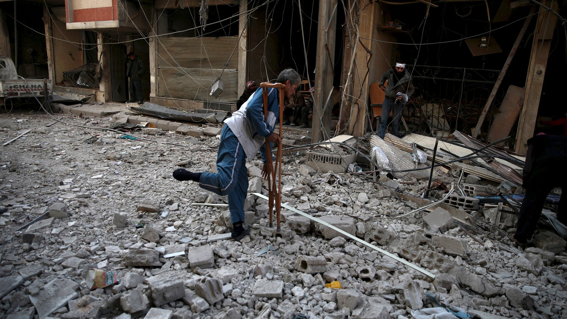 Dec. 13, 2015: Men search for belongings at a site hit by missiles in the Douma neighborhood of Damascus, Syria (REUTERS).