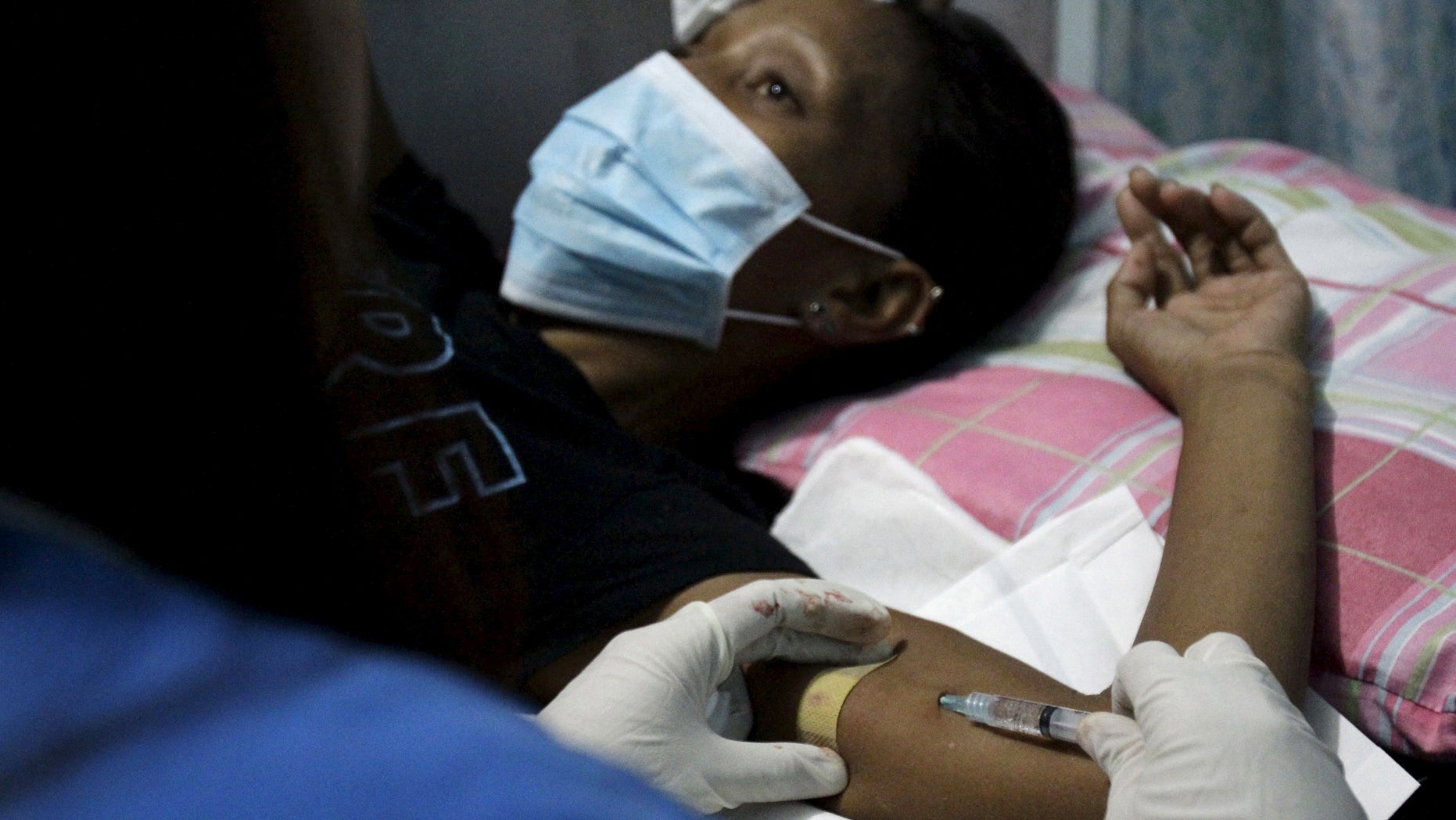 A health worker inserts an injectable contraceptive into a woman's arm during a reproductive health clinic run by an Non-Governmental Organization (NGO) in Tondo city, metro Manila January 12, 2016.