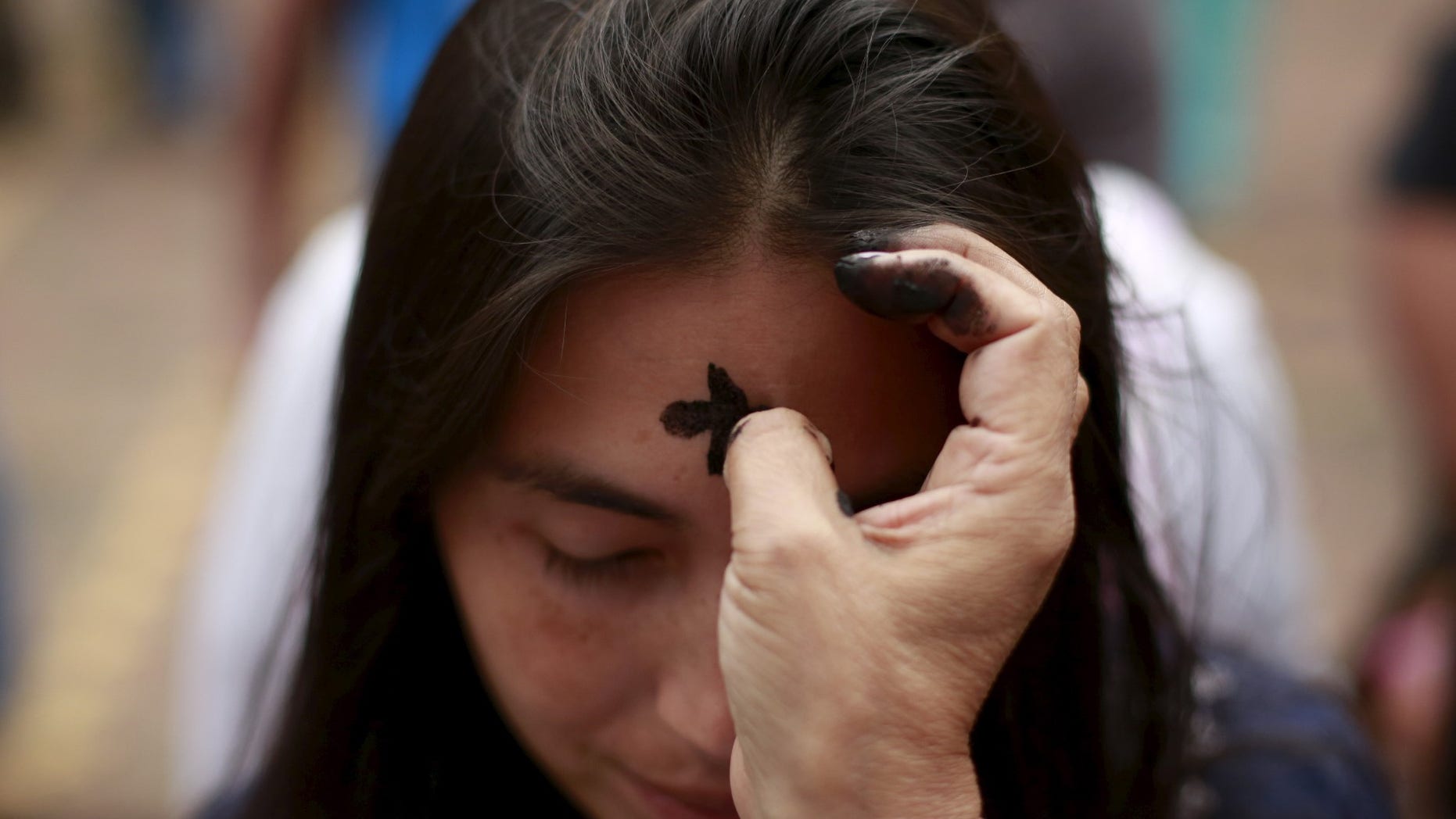 FILE -- A woman receives a cross of ashes during the traditional Ash Wednesday service.