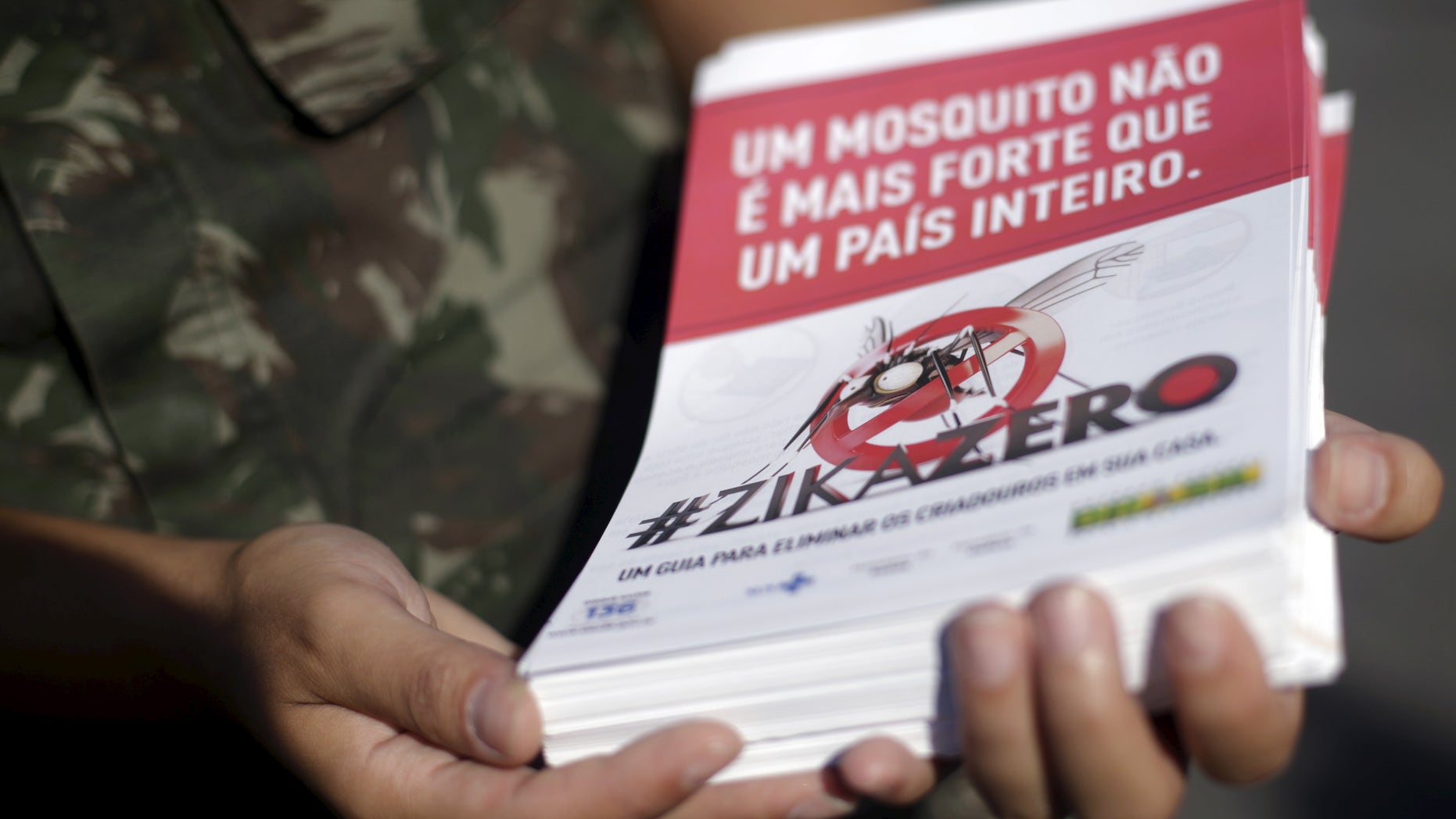 A Brazilian Army soldier shows a pamphlet which will be distributed in the city, after a ceremony to mark the graduation from training on how to combat the Aedes aegypti mosquito in Rio de Janeiro, Brazil, February 12, 2016. The pamphlet reads, "A mosquito is not stronger then an entire country."