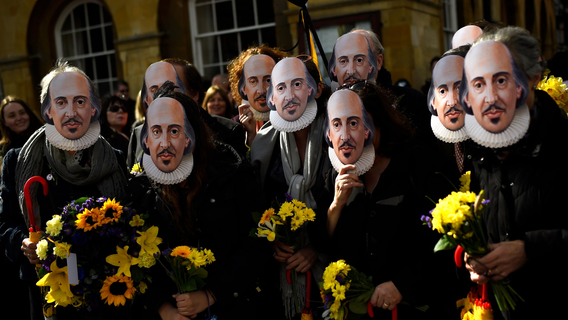 People hold up face masks with William Shakespeare's portrait during celebrations to mark the 400th anniversary of the playwright's death in the city of his birth, Stratford-Upon-Avon, Britain, April 23, 2016. (REUTERS/Dylan Martinez)