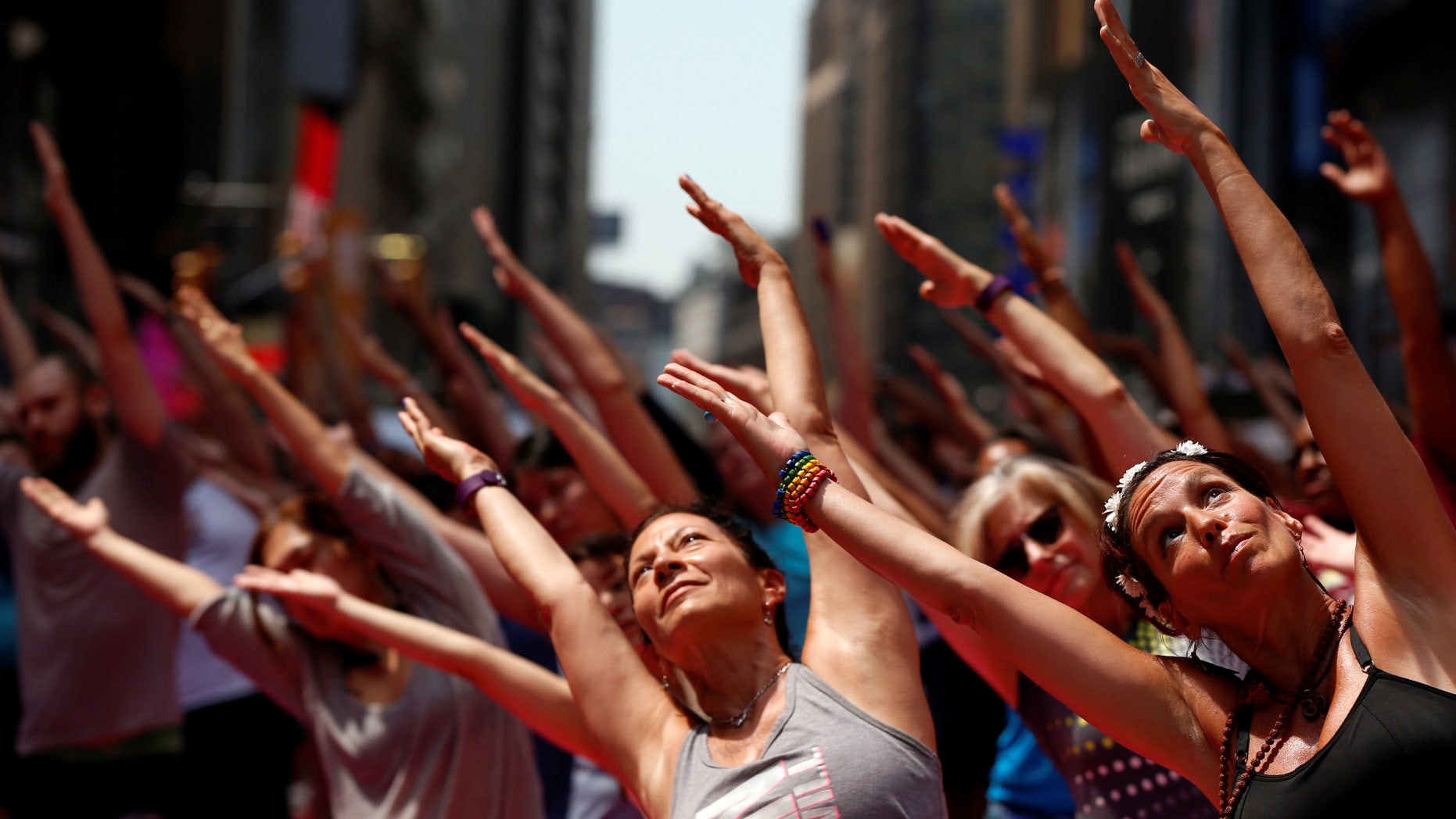 People participate in a yoga class during the 14th Annual Solstice in Times Square event in New York, U.S., June 20, 2016