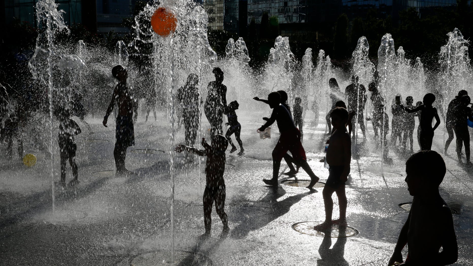 File photo: People are seen in silhouette as they cool off in water fountains in a park as hot summer temperatures hit Paris, France, August 24, 2016. (REUTERS/Pascal Rossignol)