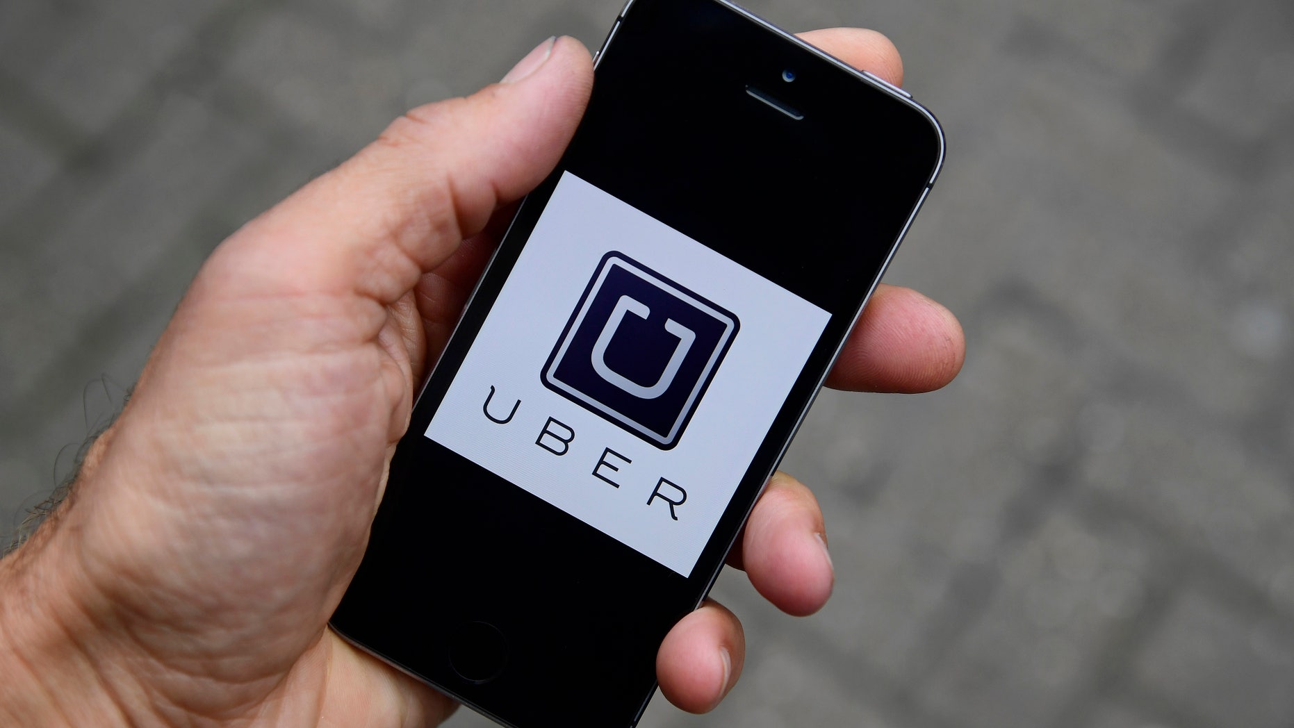 A photo illustration shows the Uber app logo displayed on a mobile telephone, as it is held up for a posed photograph in central London, Britain October 28, 2016. REUTERS/Toby Melville/Illustration - RTX2QUZ9