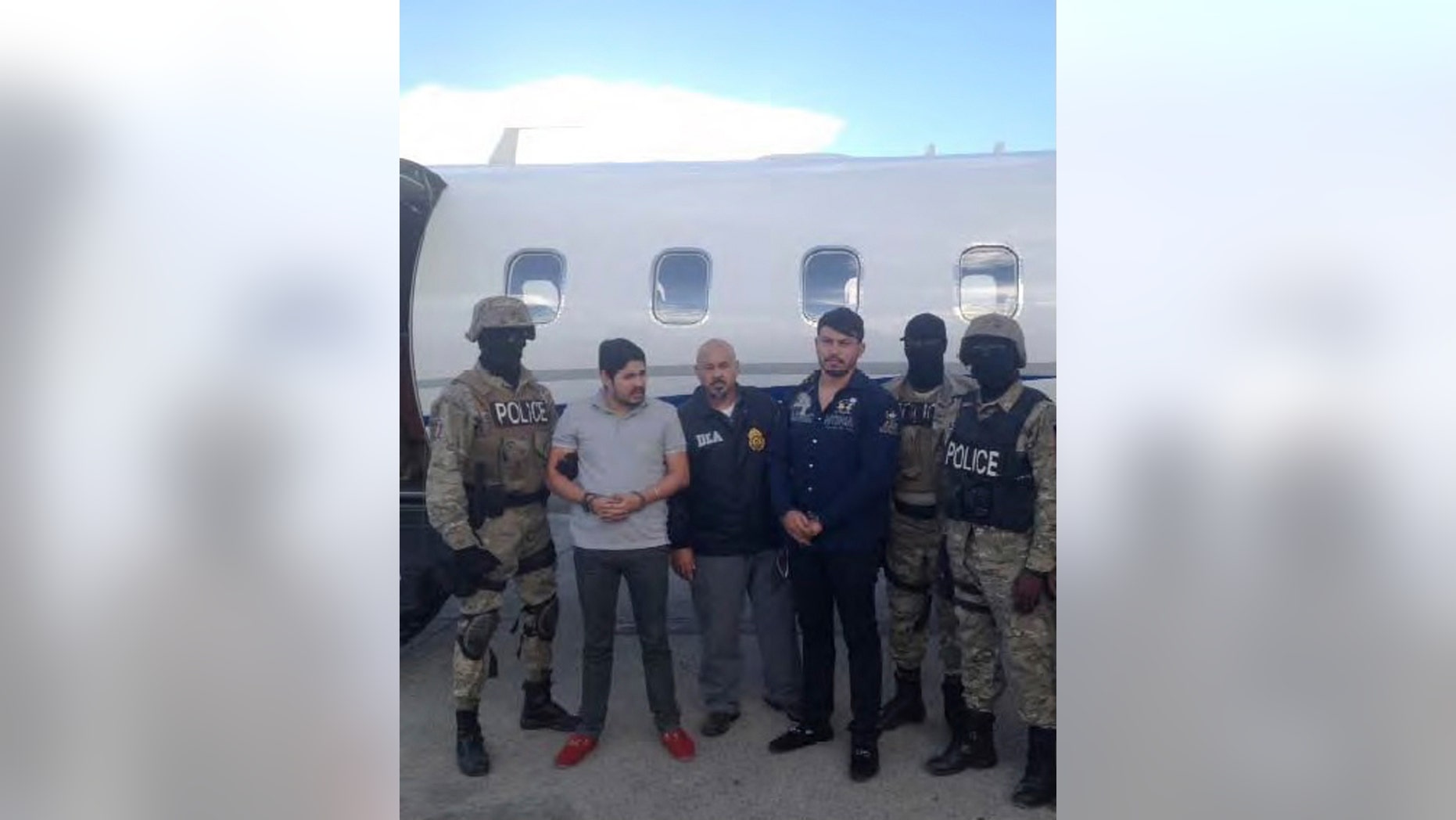 Efrain Antonio Campo Flores (2nd from L) and Franqui Francisco Flores de Freitas stand with law enforcement officers in this November 12, 2015 photo after their arrest in Port Au Prince, Haiti.