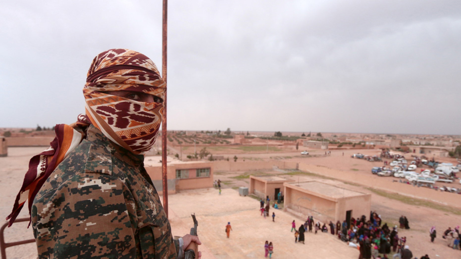A Syrian Democratic Forces (SDF) fighter overlooks people fleeing areas surrounding Euphrates River dam, east of Raqqa city, Syria March 30, 2017. REUTERS/Rodi Said - RTX33FPL