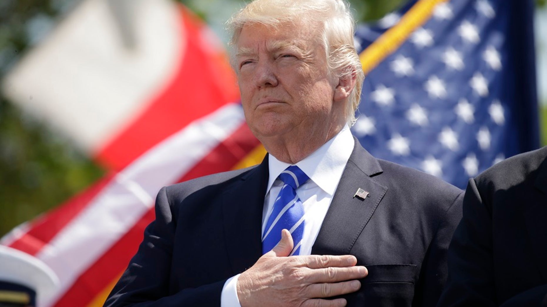 President Donald Trump holds his hand over his heart for the U.S. National Anthem as he attends the Coast Guard Academy commencement ceremonies to address the graduating class in New London, Connecticut, U.S. May 17, 2017.