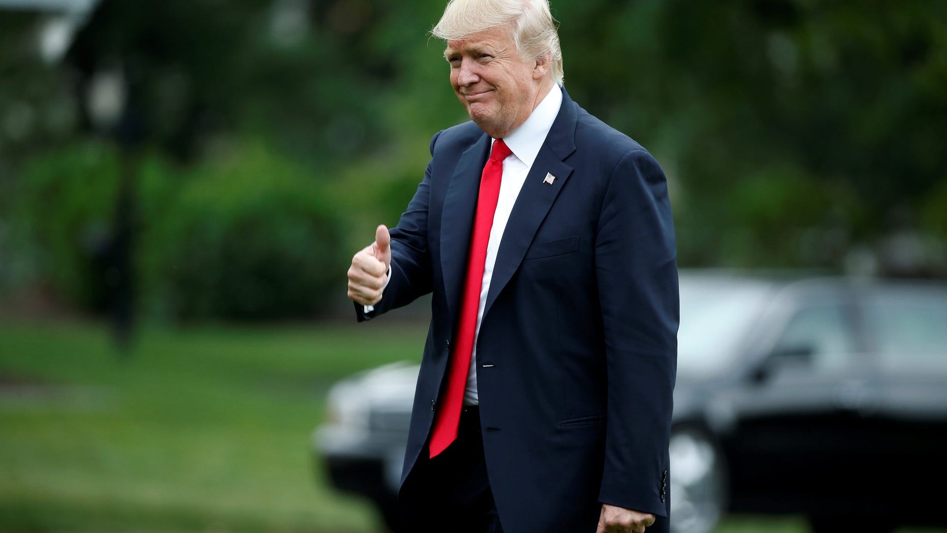 FILE -- President Donald Trump gives a thumbs up as he returns from a day trip to Ohio at the White House in Washington, June 7, 2017.