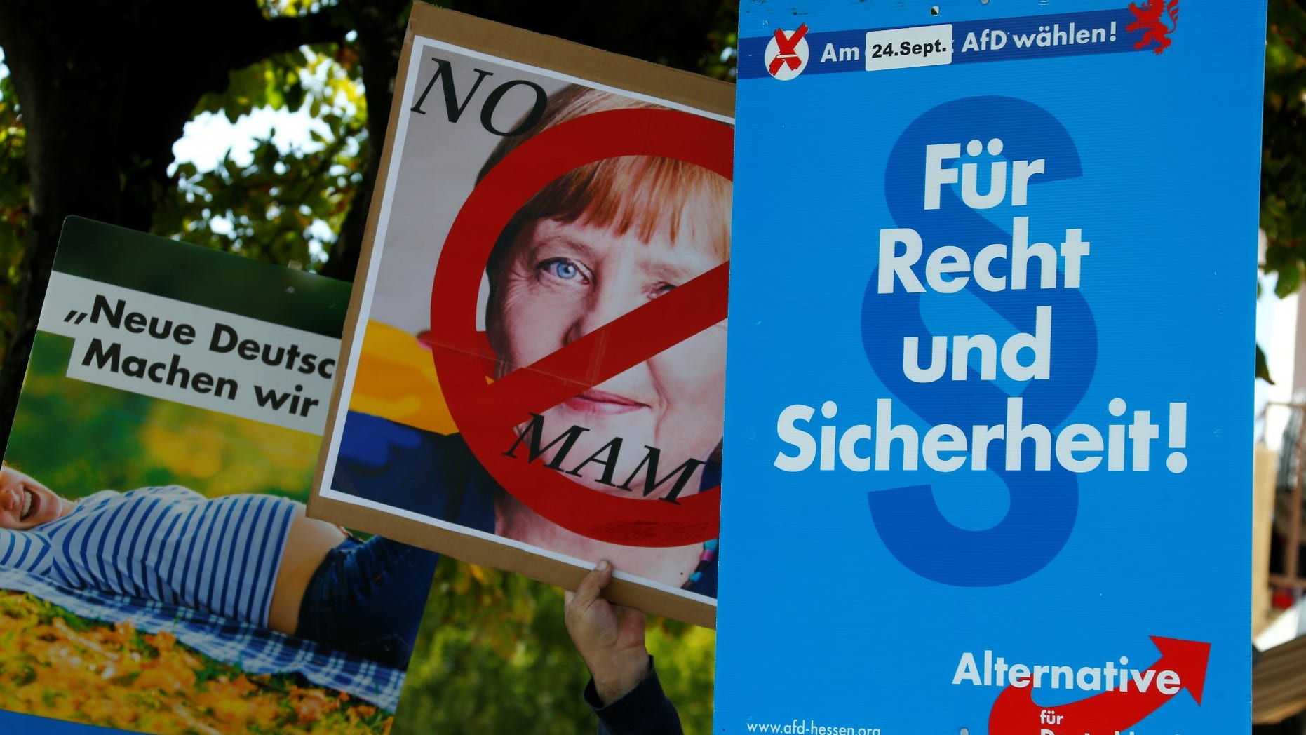 people hold anti-immigration party Alternative fuer Deutschland AfD placards as they protest against German Chancellor Angela Merkel campaigning in Heppenheim, Germany, September 22, 2017.