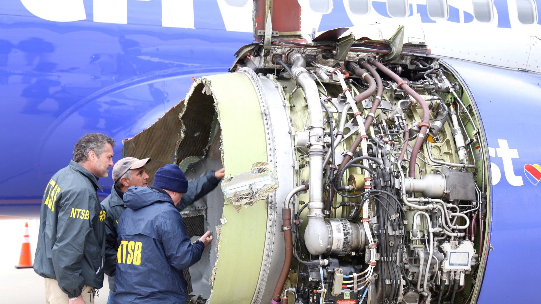 Investigators from the National Transportation Safety Board examine damage to the engine of the Southwest Airlines plane in Philadelphia, April 17, 2018.