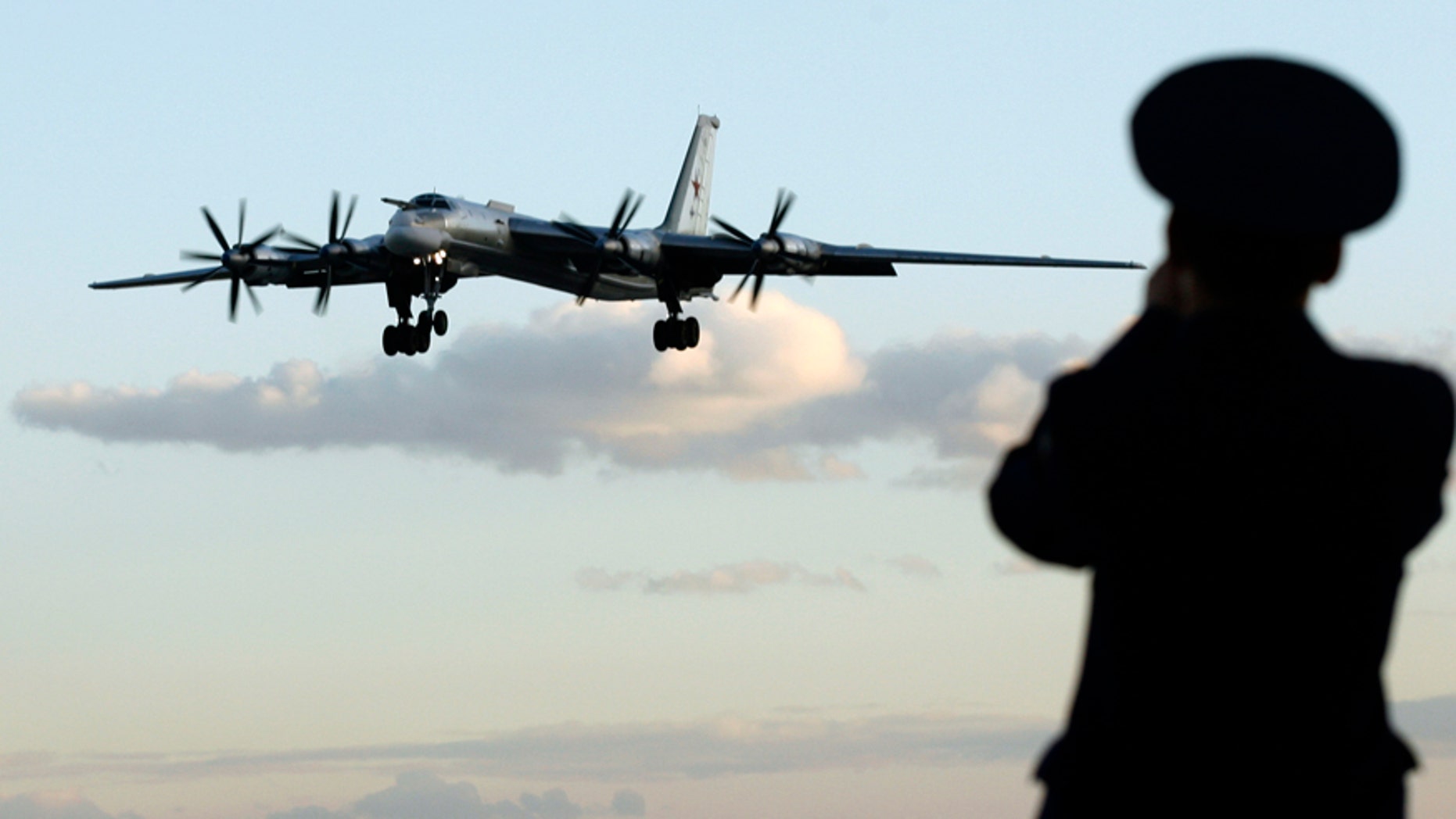 A Russian officer takes a picture of a Tu-95 bomber, or "Bear," at a military airbase in Engels, some 900 km (559 miles) south of Moscow, August 7, 2008. Picture taken August 7, 2008. Two Tu-160 jets, known to Russian pilots as "White Swans" flew this month from this base on the Volga river to Venezuela, a mission calculated to show Russia was not afraid to flex its military muscles right under the nose of the United States.To match feature RUSSIA-BOMBERS/ REUTERS/Sergei Karpukhin (RUSSIA) - RTX8W9J