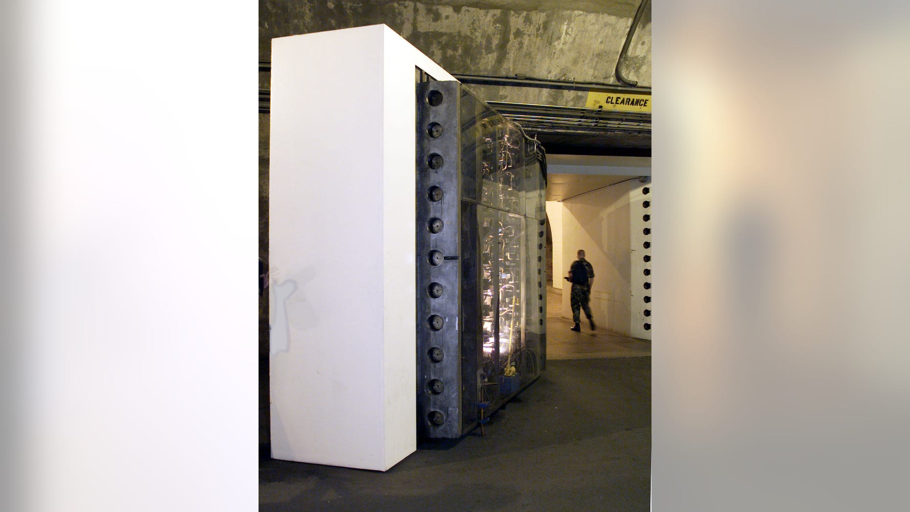 A armed guard walks past a blast-proof 25-ton steel door protecting the Cheyenne Mountain complex, home of NORAD. Picture taken October 14, 1999.