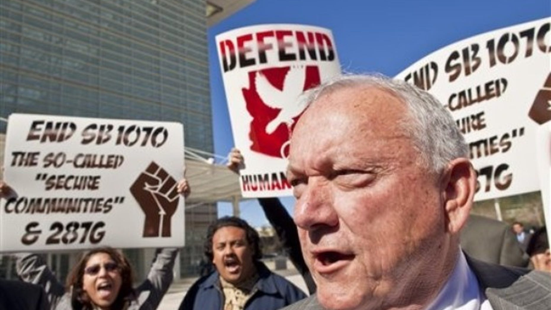 Protesters gather around Arizona State Sen. Russell Pearce, R-Mesa, Thursday, Feb. 10, 2011, outside the Sandra Day O'Connor Federal Courthouse in Phoenix. (AP)