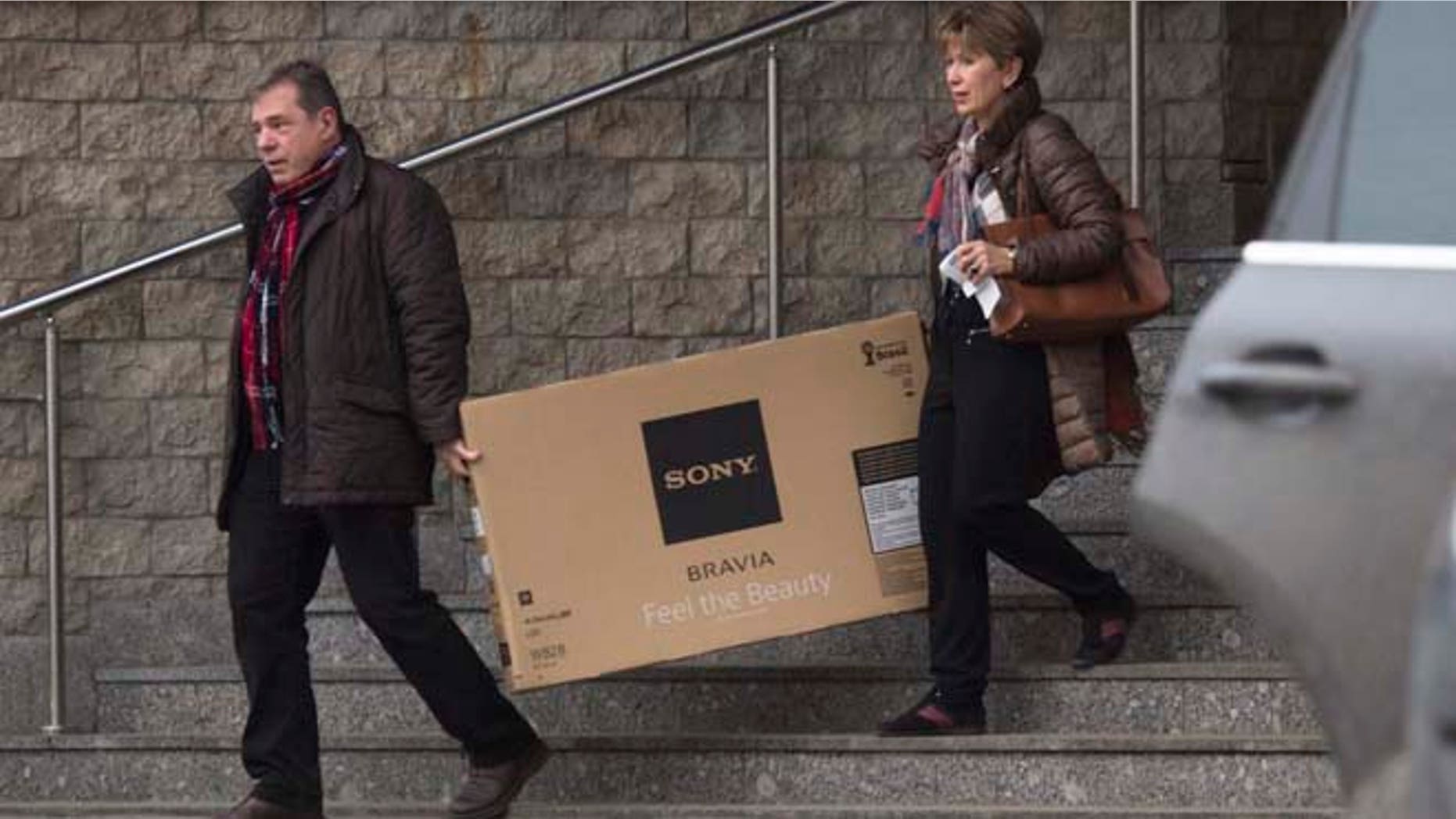Dec. 17, 2014: A couple carry a television set they purchased from a shop in St. Petersburg, Russia. The collapse of the national currency triggered a spending spree by Russians desperate to buy cars and home appliances before prices shoot higher. Several car dealership were reported to have suspended sales, unsure how far down the ruble will go, while Apple halted all online sales in Russia.