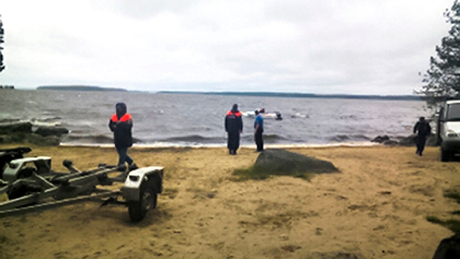 Russian Ministry for Emergency Situations workers stand at the site of an incident at a lake in the Karelia region.