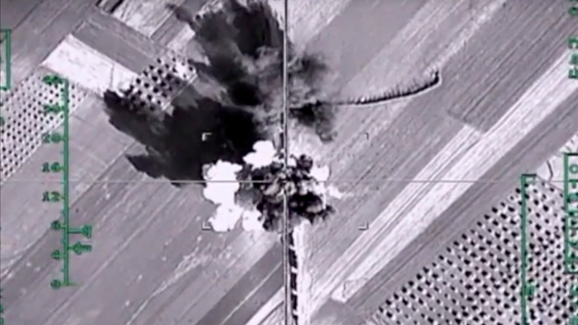In this photo made from the footage taken from Russian Defense Ministry official web site on Monday, Feb. 1, 2016, an aerial image shows what it says is a column of heavy trucks carrying ammunition hit by a Russian air strike near Aleppo, Syria.