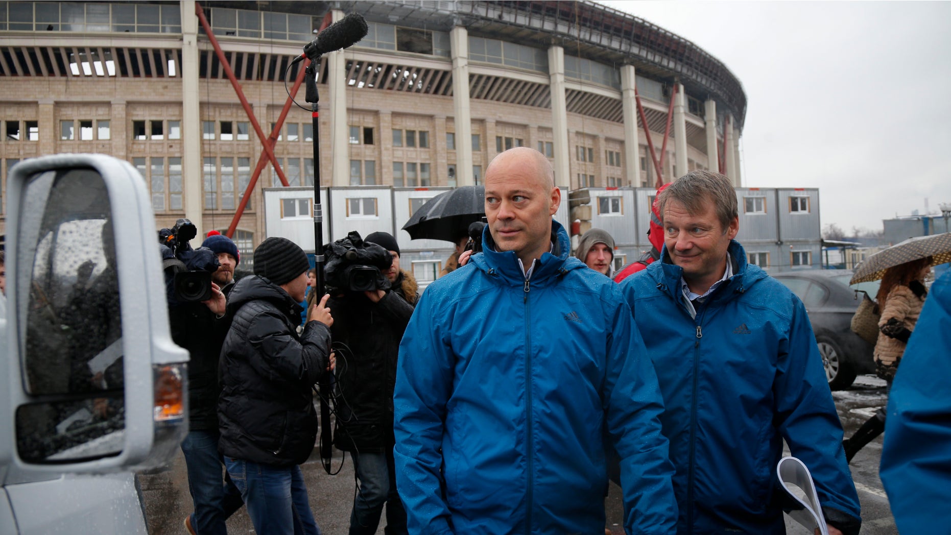 Oct. 20, 2014: Chris Unger, the head of FIFA's monitoring group for the 2018 World Cup, center, walks to a bus after his news conference at the Luzhniki Stadium which will host the final of the 2018 World Cup in Moscow
