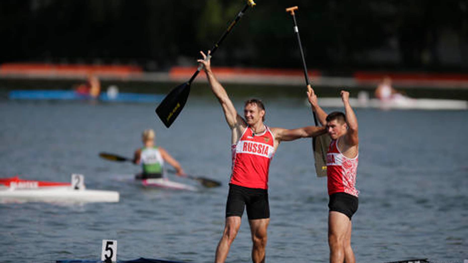 Nikolay Lipkin, left, and Andrey Kraitor of Russia celebrate after they won the C1 relay men 200m final of the ICF Canoe Sprint World Championships 2014 in Moscow, Russia, on Aug. 10, 2014. The International Canoe Federation says it has barred five Russian competitors from the Rio Olympics.