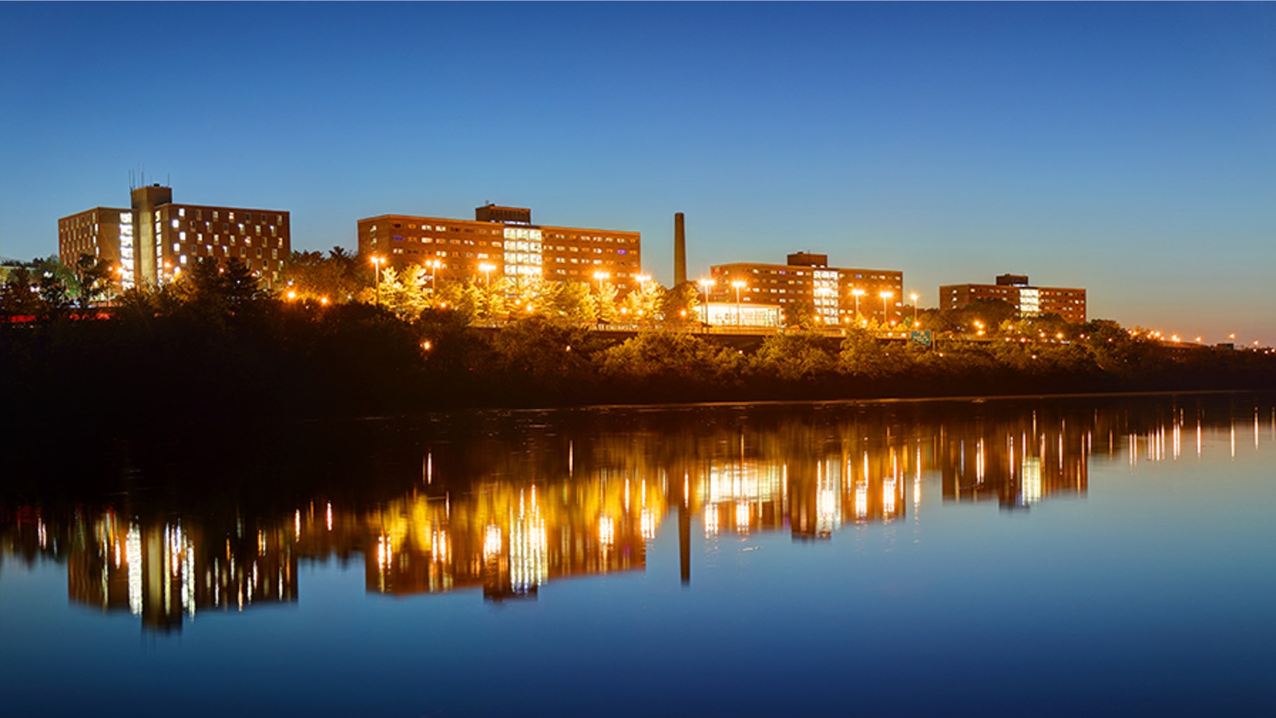 Night view of the Rutgers University campus Halls reflecting on a calm Raritan River