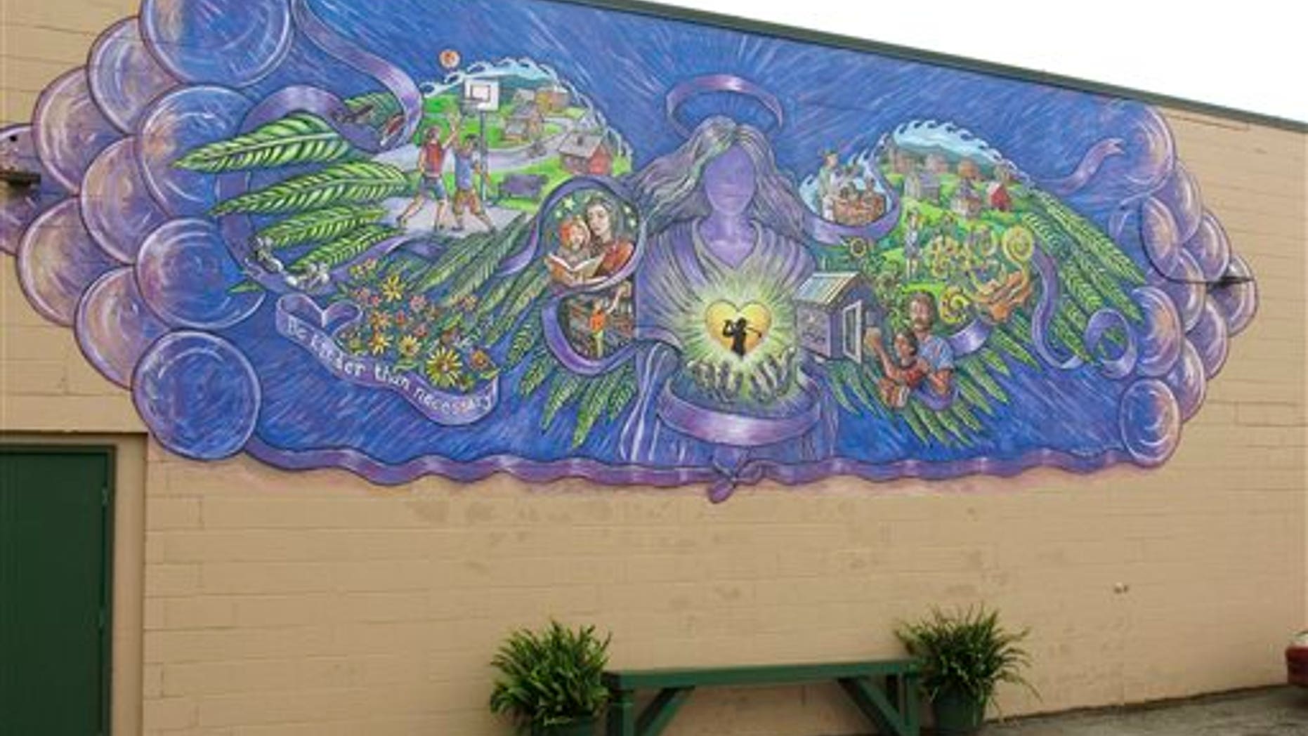 In this Oct. 1, 2015 photo, a mural covers the wall of a store in Rutland, Vt., commemorating the life of 17-year-old Carly Ferro, a star athlete, who was hit by a car and killed while leaving her job at the store. (AP Photo/Wilson Ring)