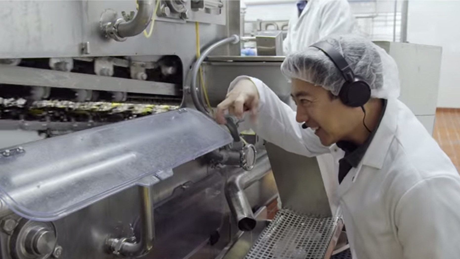 Grant Imahara inspects the egg-breaking machine.