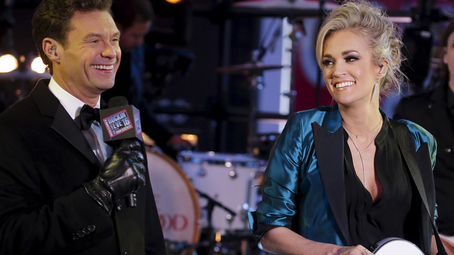 TV host Ryan Seacrest (L) introduces Singer Carrie Underwood on the main stage in Times Square during New Year's Eve celebrations in the Manhattan borough of New York, December 31, 2015. REUTERS/Carlo Allegri - RTX20OYT