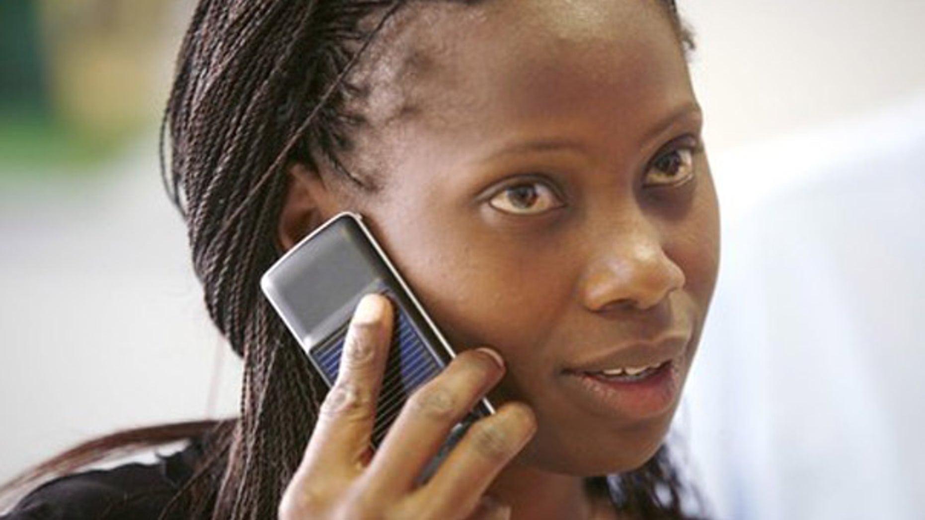 A Safaricom client uses a solar-charged mobile phone handset at a retail centre in Kenya's capital Nairobi, in this September 22, 2009 file photo. Solar cellphones could build on the economic advantages that mobile phones have already brought to far-flung regions of Africa and the Indian subcontinent, including price transparency and more accurate and timely information. Mobile phone penetration in these regions has been held back by a lack of electricity: there is simply no way to charge a cellphone in many rural areas of developing countries. To match feature CELLPHONES-SOLAR/. REUTERS/Thomas Mukoya/Files (KENYA BUSINESS SCI TECH)