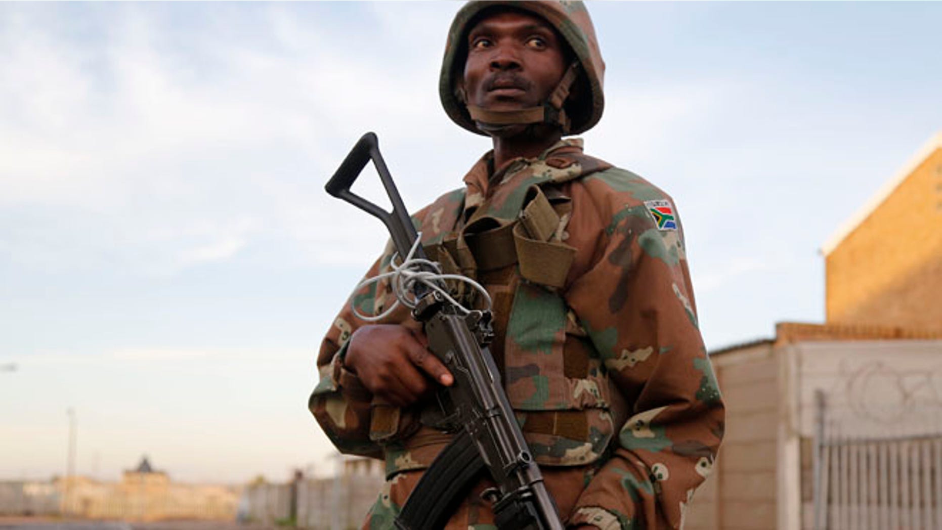 May 21, 2015: A South African soldier provide security for policemen as they look for drugs in Manenberg, South Africa. (AP)
