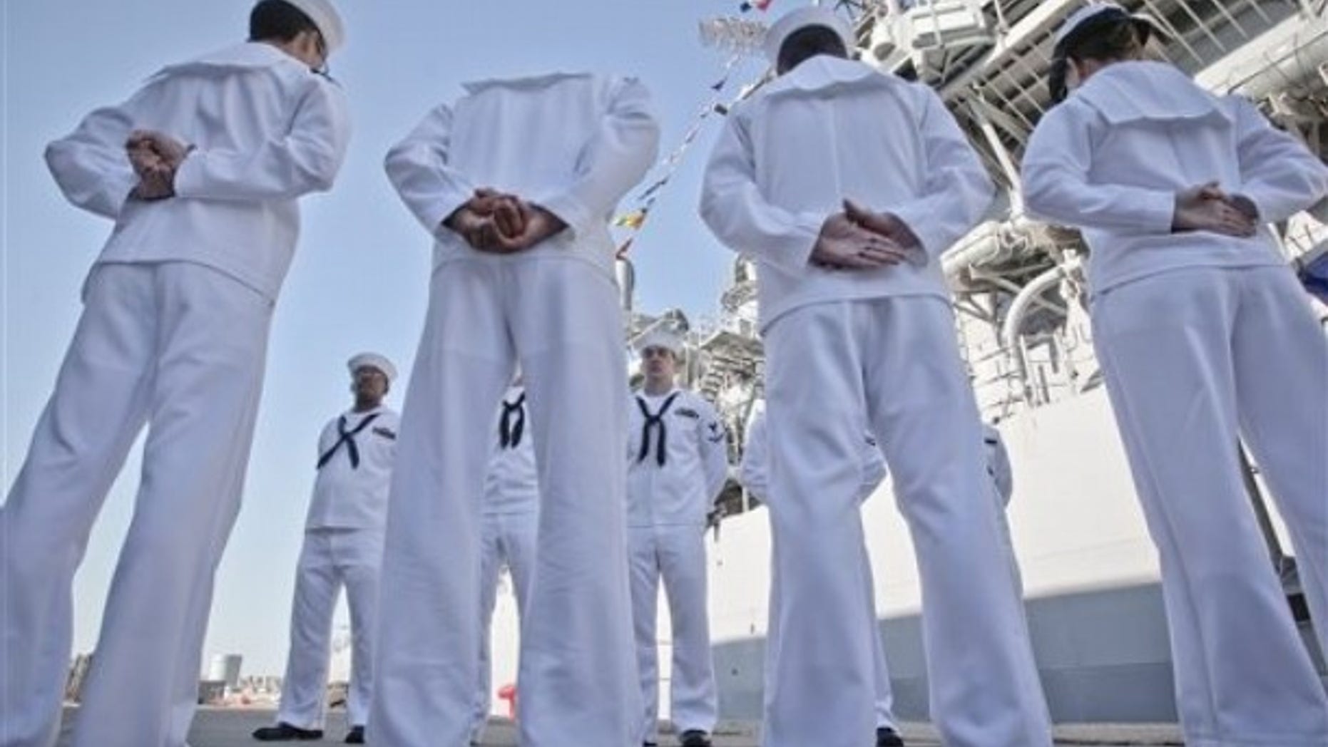 U.S. sailors of the USS Monterey stand next to their vessel in the Black Sea port of Constanta, Romania, Tuesday, June 7, 2011.
