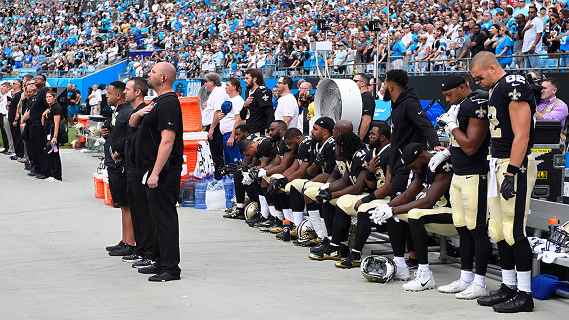 New Orleans Saints players stand and sit during the national anthem at Bank of America Stadium in Charlotte, N.C. on Sept. 24.
