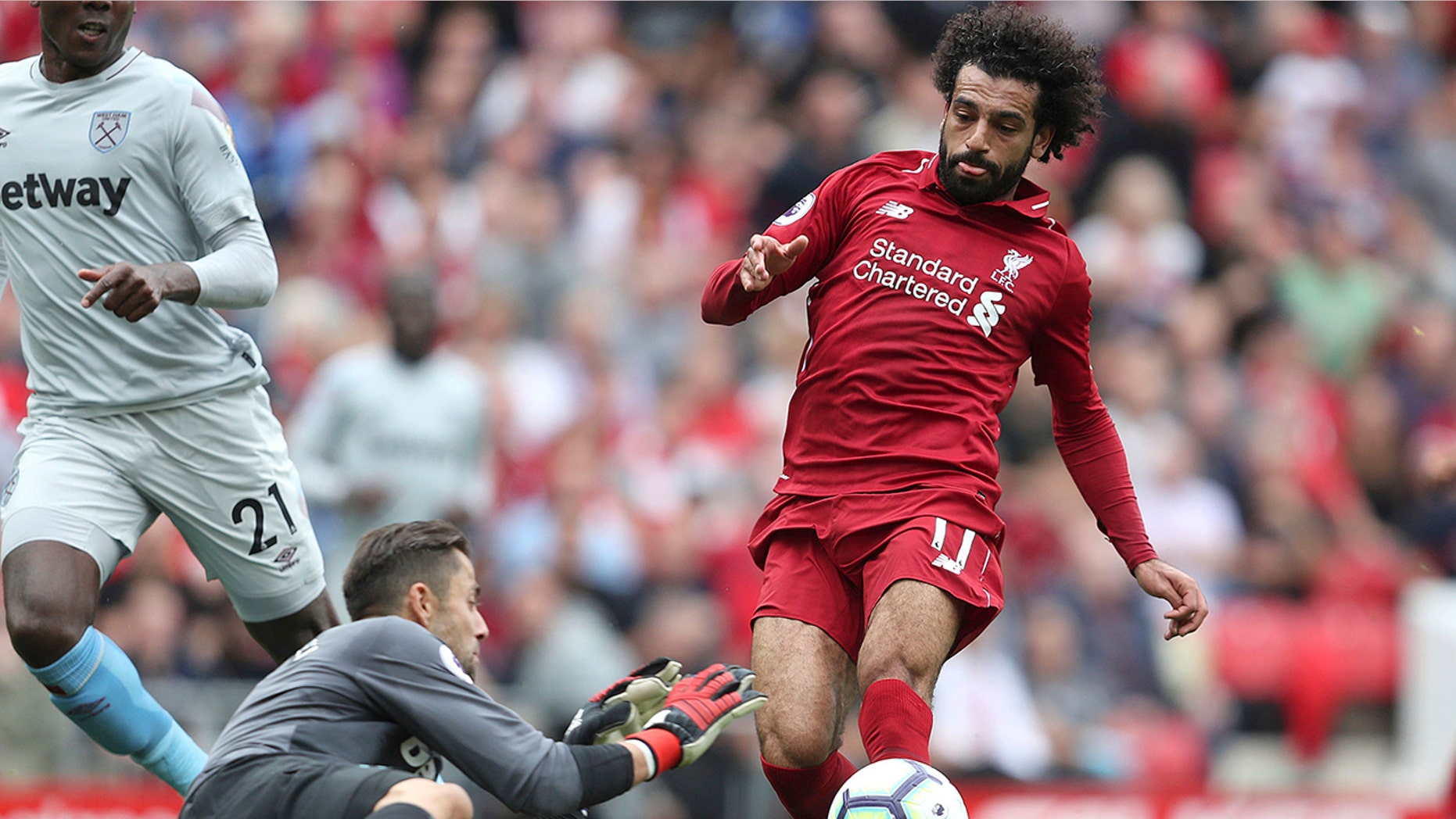 West Ham United goalkeeper Lukasz Fabianski makes a save from Liverpool's Mohamed Salah during the Premier League soccer match between Liverpool and West Ham United at Anfield, Liverpool, England. Sunday Aug. 12, 2018. (David Davies/PA via AP)