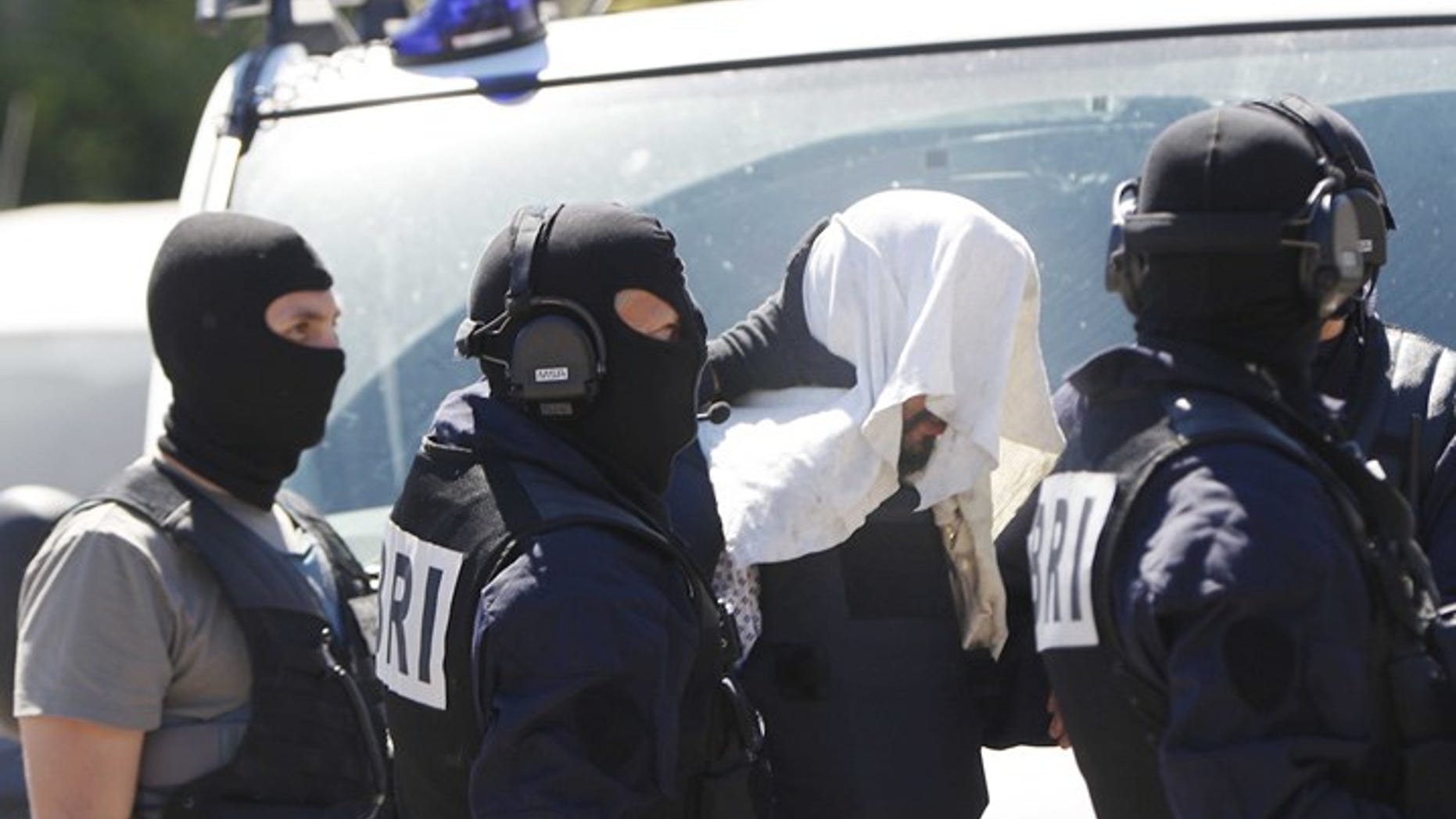 Yassin Salhi after his arrest in June, with a towel covering his head.