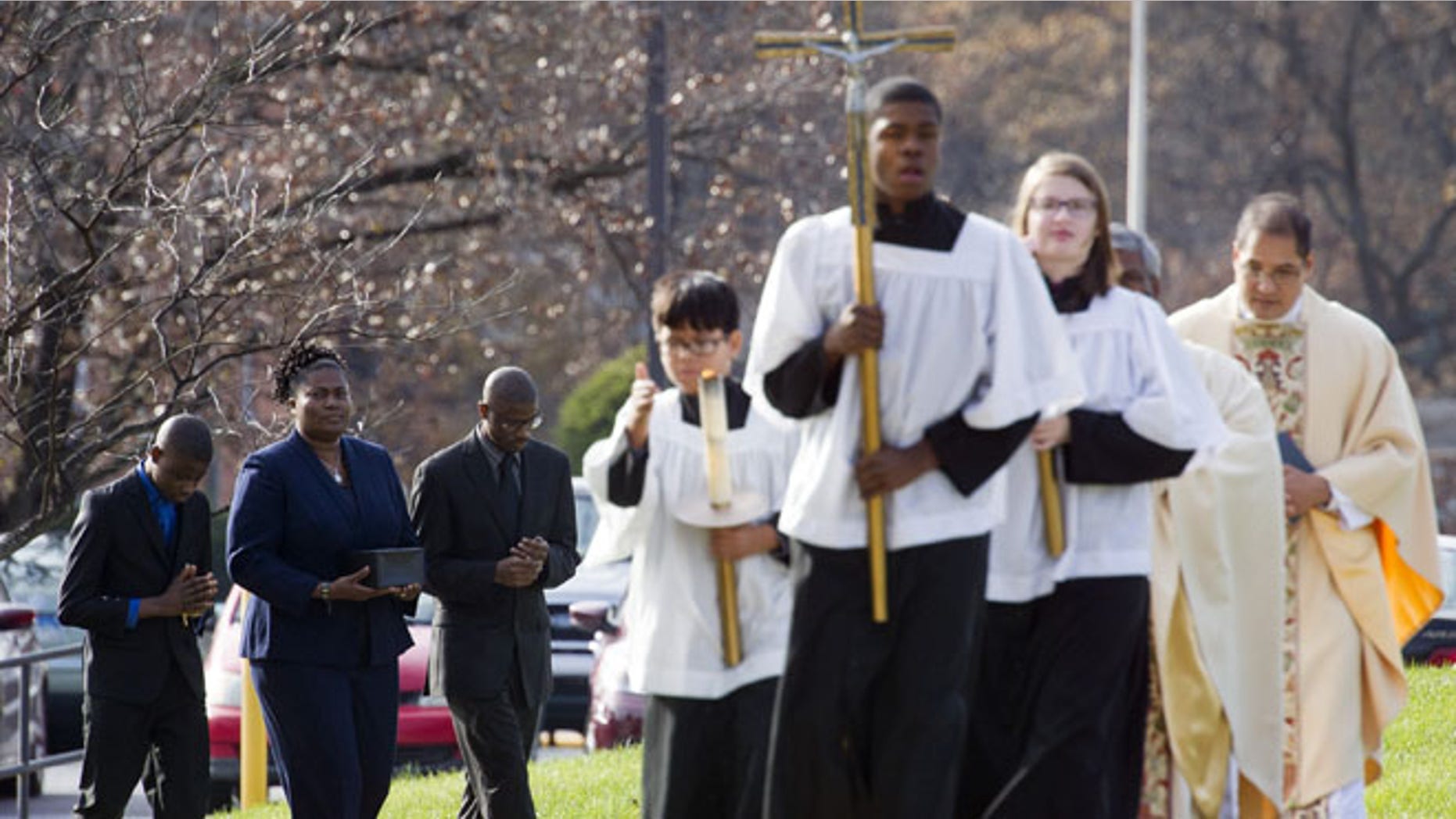 Nov. 29, 2014: Isatu Salia, second from left, carries the cremated remains of her husband, Dr. Martin Salia, while their sons Maada Martin Salia, 20, third from left, and Hinwaii Sakatty Salia, 12, left, walk with her to enter St. Mary's Catholic Church in Landover Hills, Md., during the funeral mass for Dr. Martin Salia. (AP)