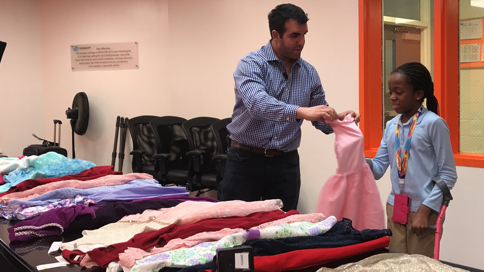 Sam Sisakhti, the founder of Us Trendy, with many of the donated dresses.