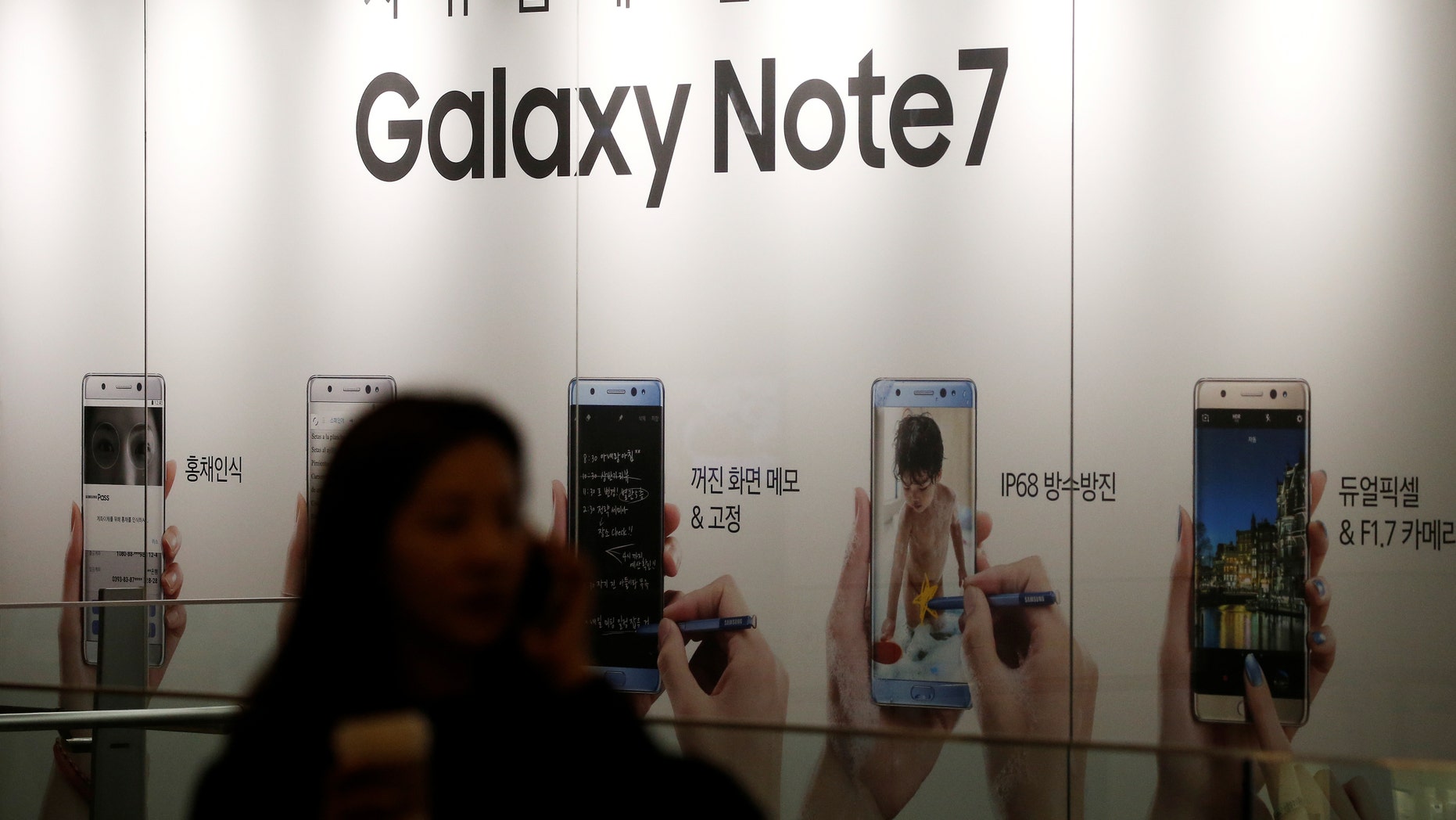 A woman talking on her mobile phone walks past an advertisement promoting Samsung Electronics' Galaxy Note 7 at company's headquarters in Seoul, South Korea, October 11, 2016. (REUTERS/Kim Hong-Ji)
