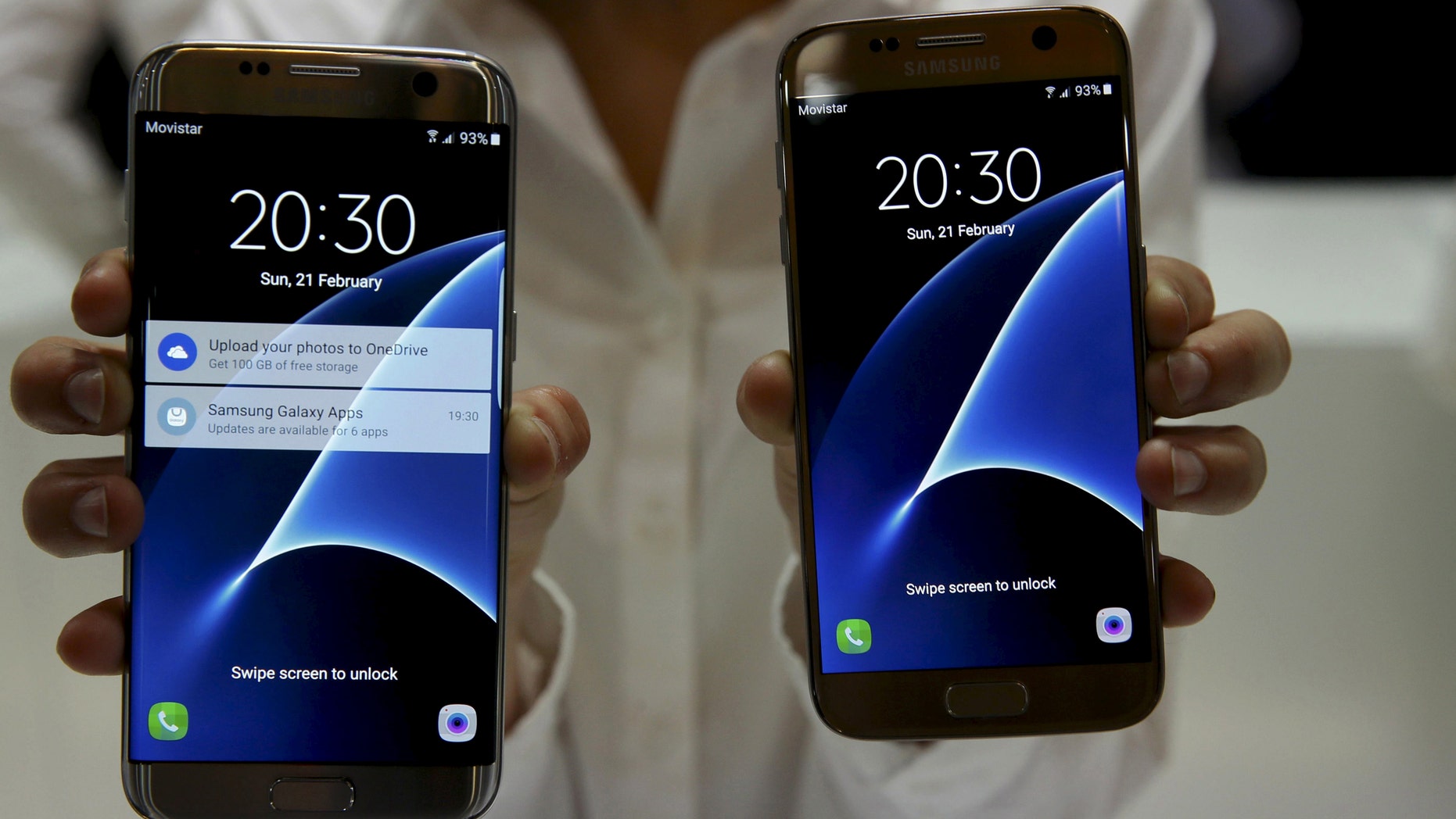 A woman displays new Samsung S7 (R) and S7 edge smartphones after their unveiling ceremony at the Mobile World Congress in Barcelona, Spain, Feb. 21, 2016. (REUTERS/Albert Gea)