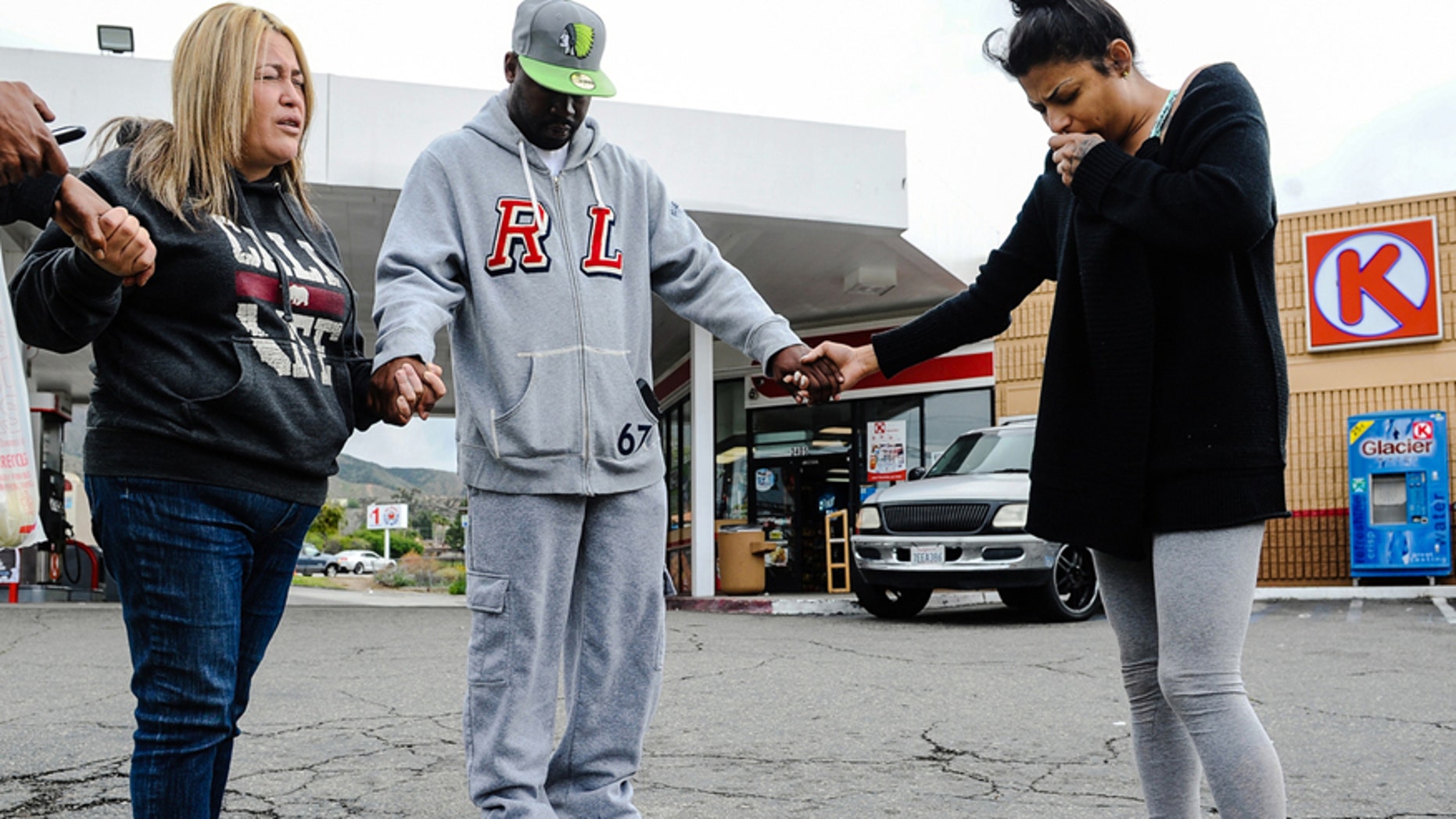 March 14, 2016: Francine Prieto-Estrada, left, leads Donald Pride and Elisa Castro in a prayer at memorial site for 12-year-old shooting victim Jason Spears at a Circle K in San Bernardino, Calif.