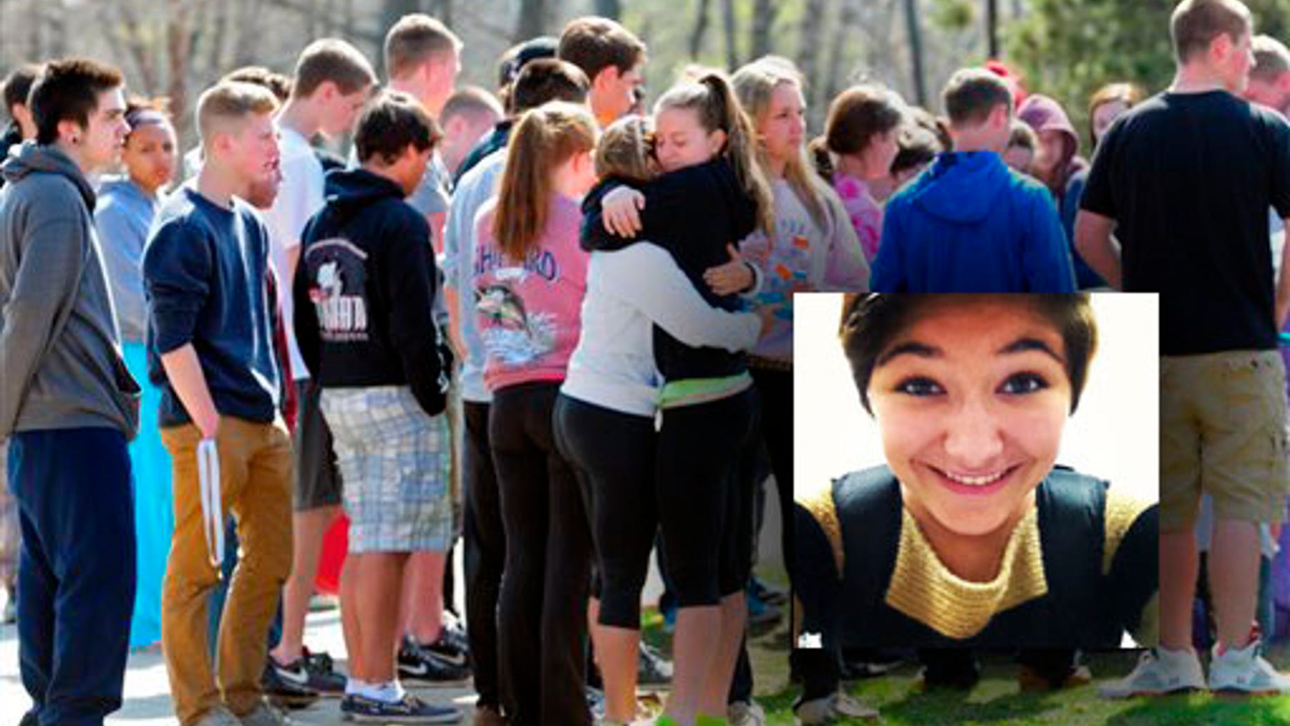 Students hug and spray paint a rock purple outside Jonathan Law High School in Milford, Conn., Friday, April 25, 2014, in memory of 16-year-old stabbing victim Maren Sanchez. Sanchez was stabbed to death earlier in the day during an altercation inside the school. A teenage boy is in custody, and police are investigating whether she was stabbed because she declined to be his date at the junior prom. (AP Photo/The New Haven Register, Peter Hvizdak) MANDATORY CREDIT