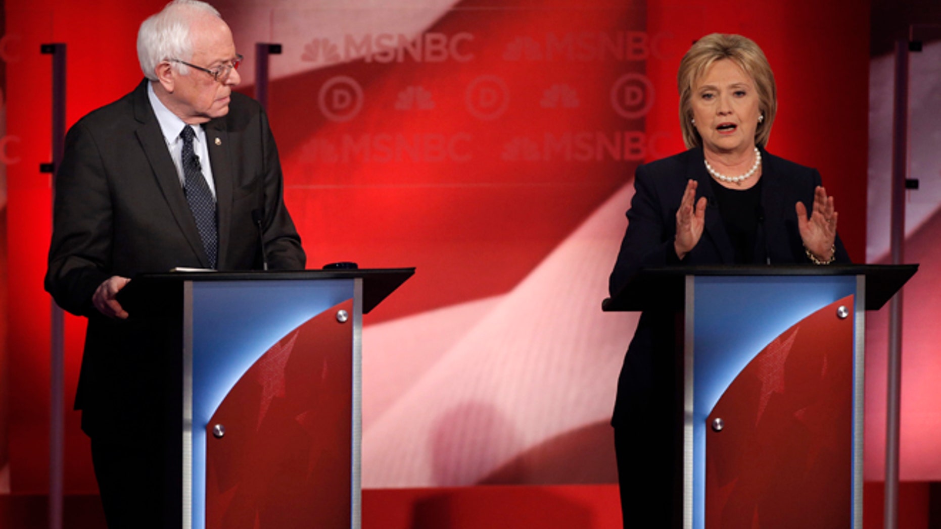 Democratic U.S. presidential candidate Senator Bernie Sanders (L) listens to former Secretary of State Hillary Clinton speak during the Democratic presidential candidates debate sponsored by MSNBC at the University of New Hampshire in Durham, New Hampshire, February 4, 2016. REUTERS/Mike Segar - RTX25IQ6