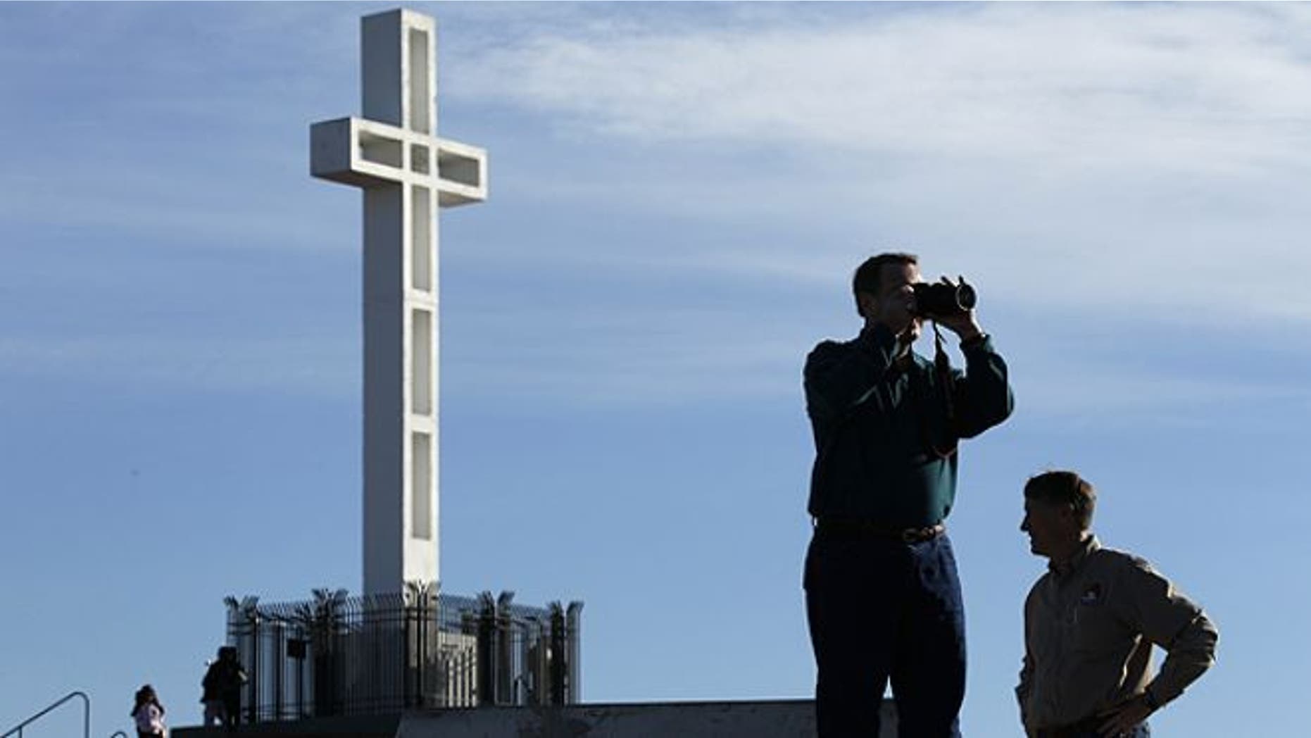 FILE: Jan. 4, 2011: Rev. John Fredericksen of Orlando, Fla., takes a picture in front of the war memorial cross on Mount Soledad in San Diego, alongside Burdette Streeter of San Diego.